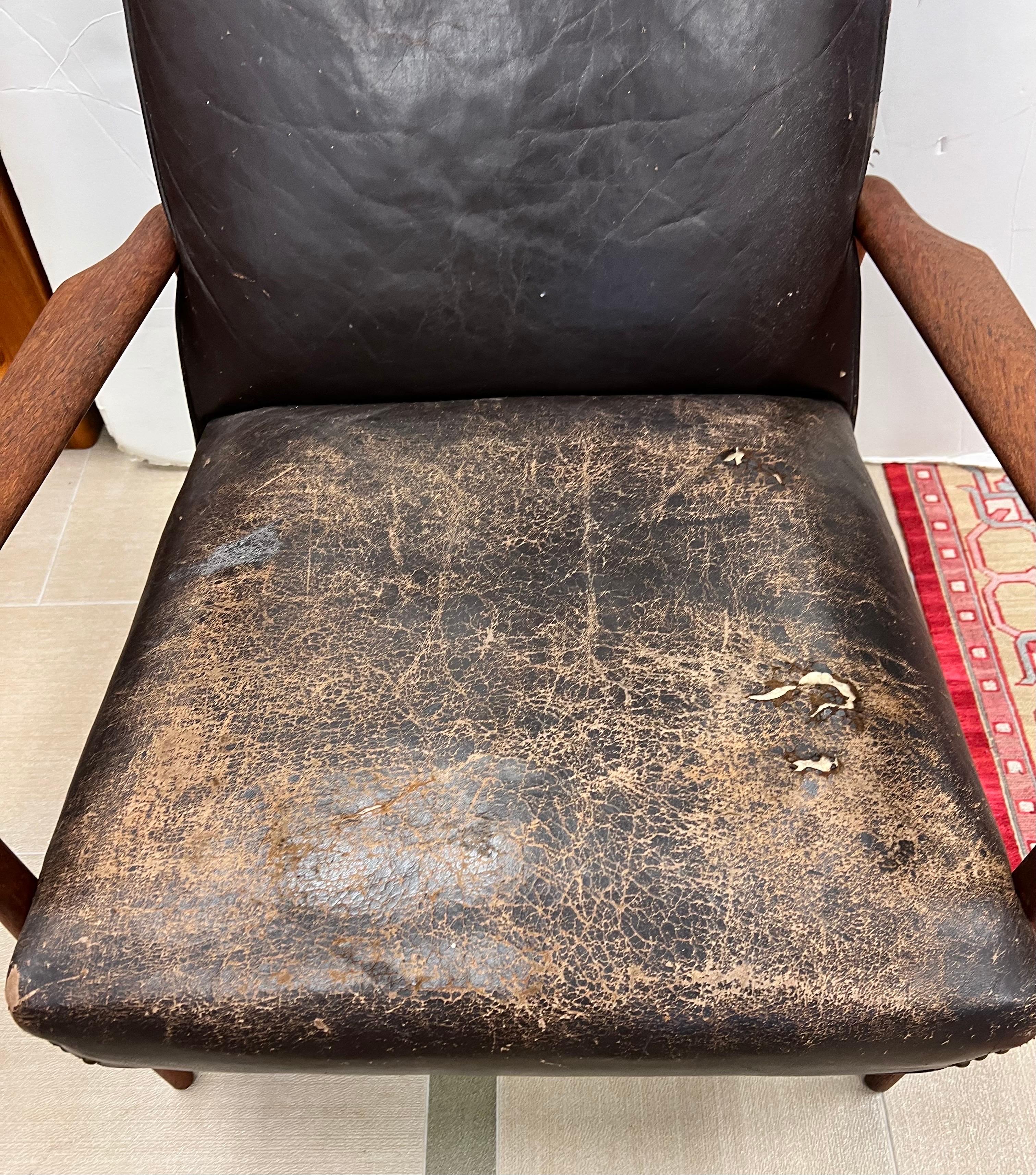 Rare Danish Modern Kofod-Larsen lounge chair done in leather upholstery which is very distressed and will need to be reupholstered. The chair is structurally sound. Priced commensurate with condition. An iconic Danish Modern masterpiece by Ib