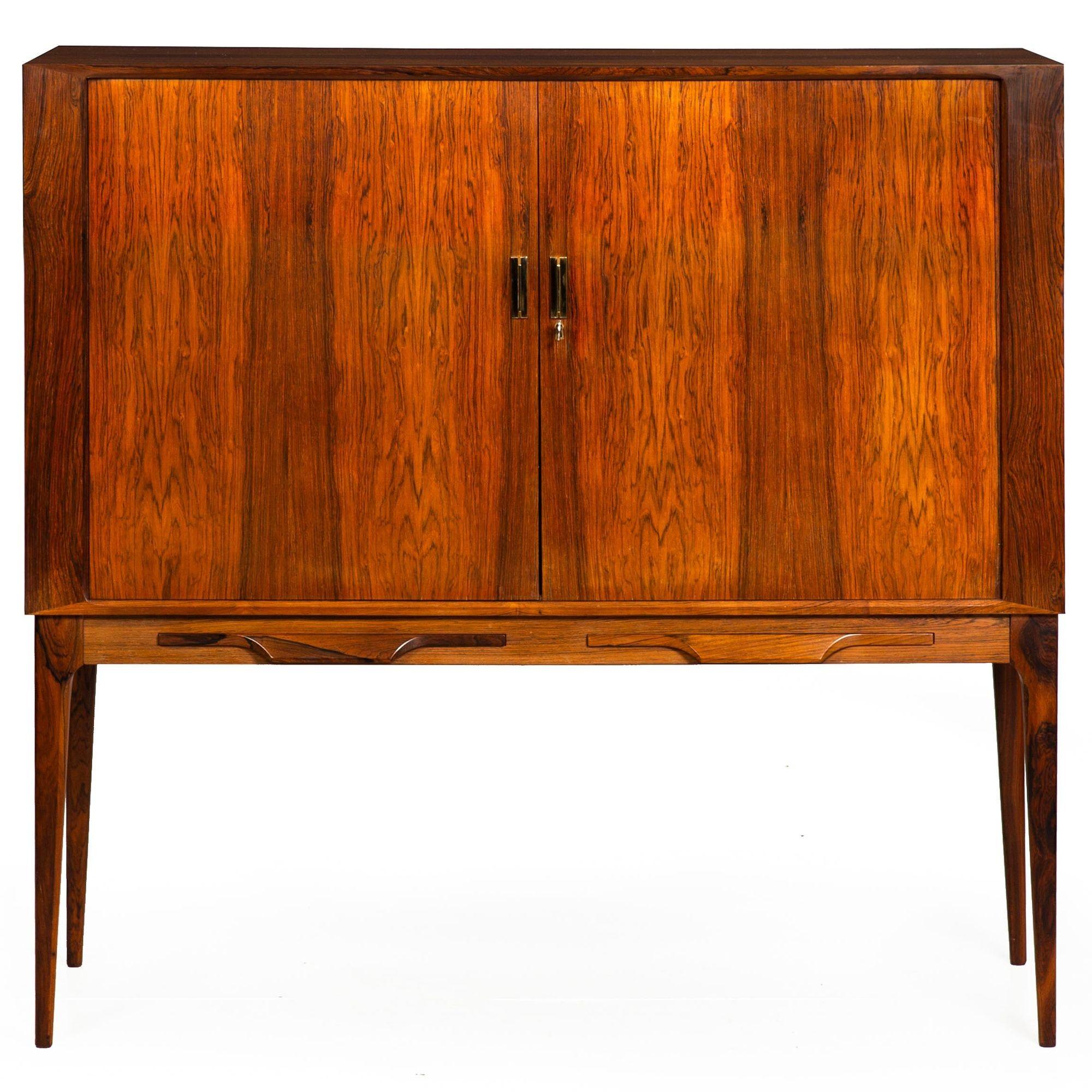RARE DANISH MODERN ROSEWOOD, BRASS AND GLASS TAMBOUR-FRONT DRY BAR CABINET
Designed by Kurt Ostervig  circa 1960s  unmarked
Item # 311WAH13A 

An exceedingly beautiful and quite rare tambour-front dry bar cabinet designed by the Danish furniture