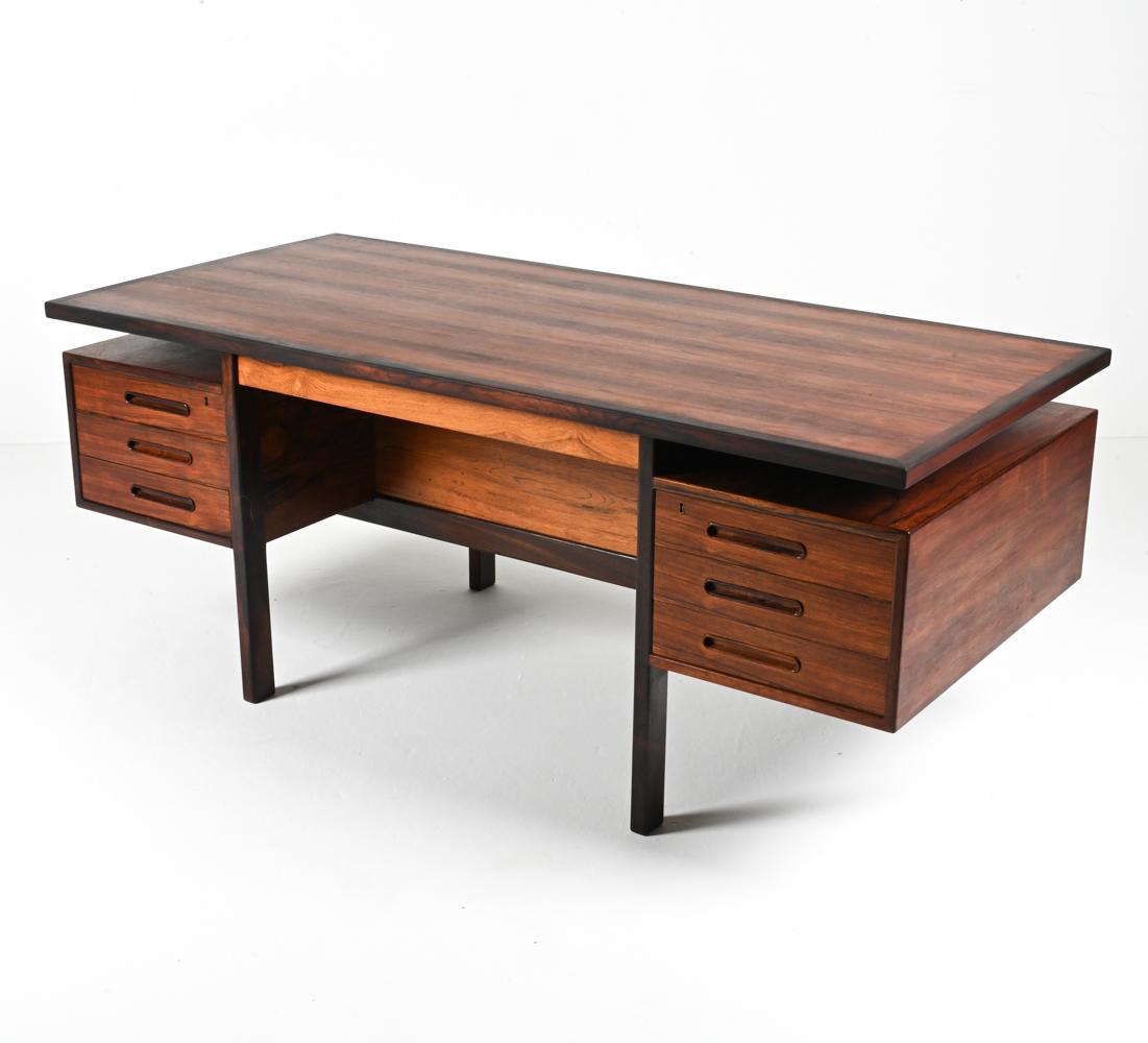 Introducing a truly exceptional and exceedingly rare Danish Mid-Century rosewood executive desk, an embodiment of iconic design attributed to the visionary duo Nanna and Jørgen Ditzel. Dating back to the 1960's and produced by the esteemed Kolds