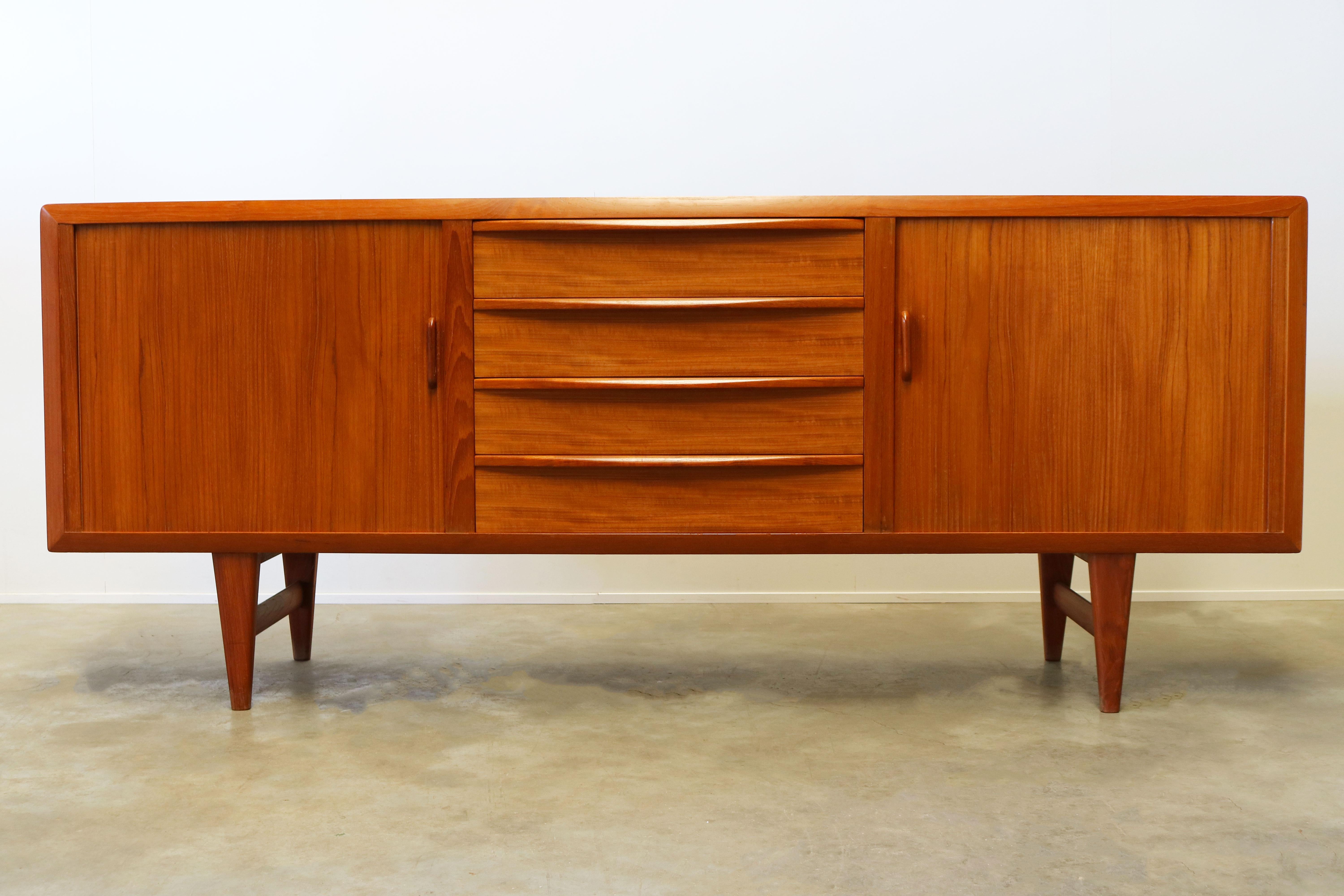 Magnificent and rare Danish design sideboard designed by: Ib Kofod-Larsen for the Faarup Mobelfabrik in the 1950s. An exceptional beautiful sideboard with organic lines and warm teak wood. The sideboard has four drawers and two tambour doors who