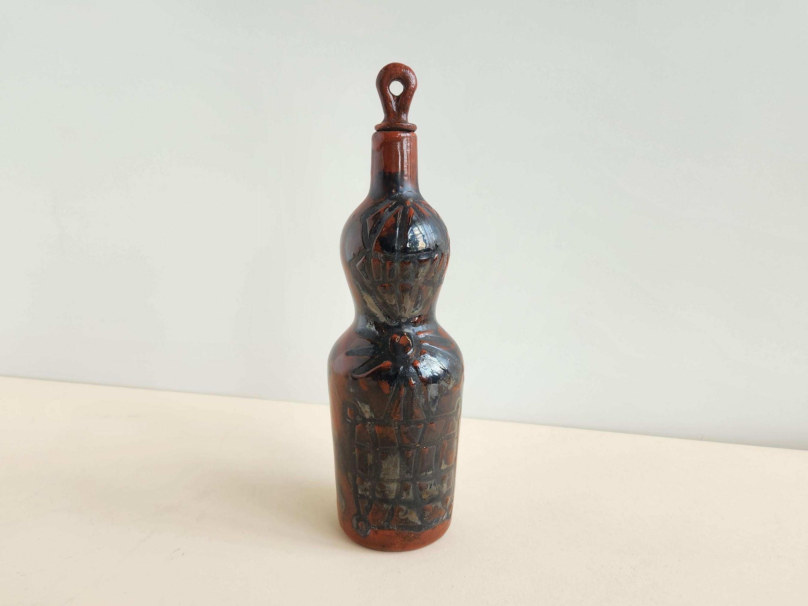 Vintage ceramic decorative flask signed by Roger Capron - Vallauris, France

Roger Capron was in influential French ceramicist, known for his tiled tables and his use of recurring motifs such as stylized branches and geometrical suns.   He was born