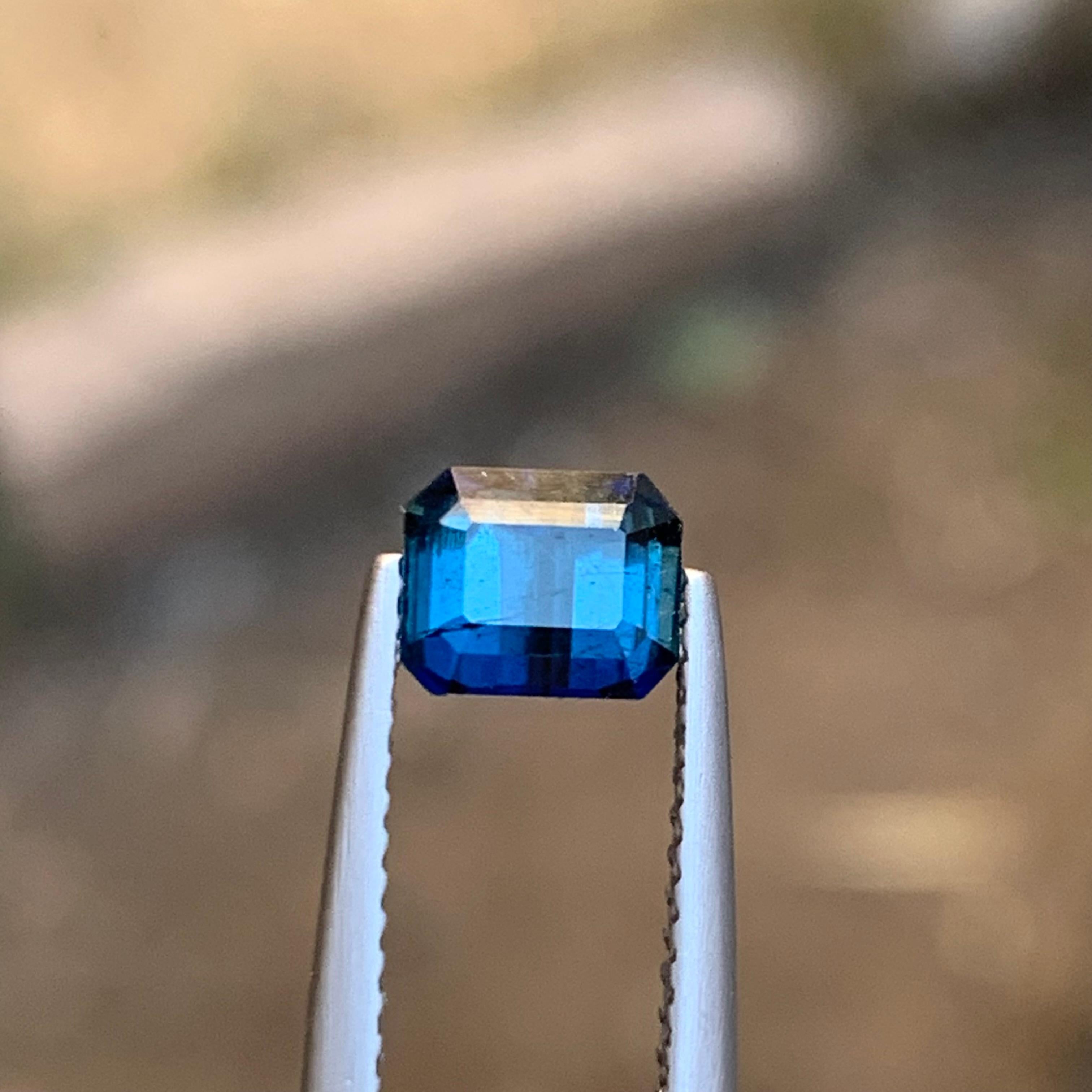 GEMSTONE TYPE: Tourmaline
PIECE(S): 1
WEIGHT: 1 Carat
SHAPE: Emerald Cut
SIZE (MM): 5 x 6.07 x 4.20
COLOR: Darkish Inky Blue
CLARITY: Slightly Included 
TREATMENT: None
ORIGIN: Afghanistan
CERTIFICATE: On demand

This stunning 1 carat tourmaline