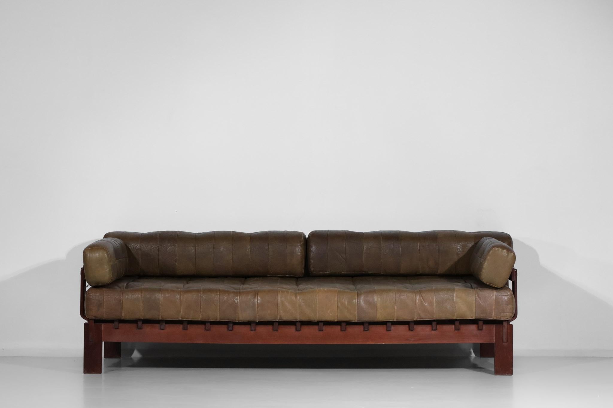 Very nice sofa from the 60's in the De Sede style. Seat, back and armrests in original brown leather patchwork, these are removable. Structure of the sofa in solid wood, stained beech. Very nice patina, traces of wear on the seats which have been