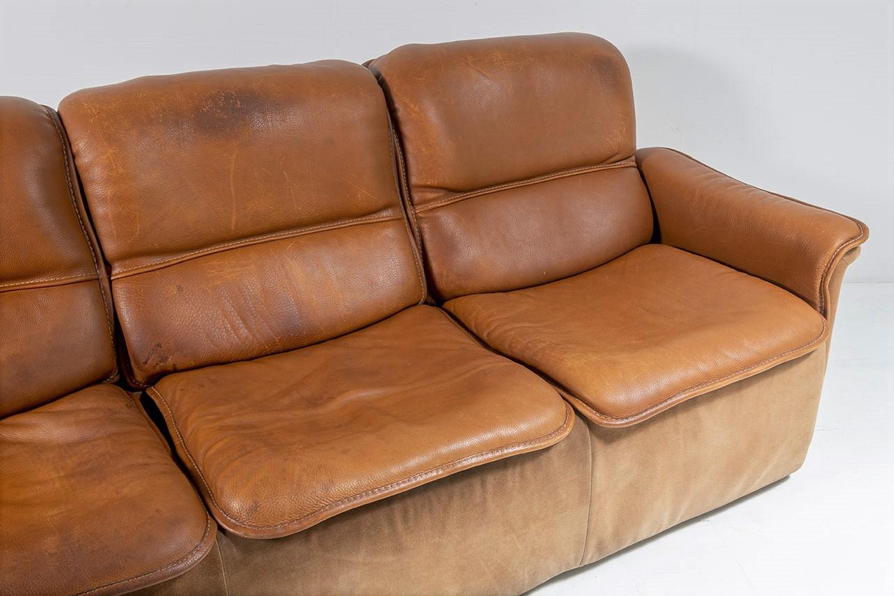 Dieses hochwertige Sofa von De Sede, das Modell DS 12 aus den 1970er Jahren, zeichnet sich durch die begehrte zweifarbige Gestaltung mit dickem, schwerem Leder für den Sitz und kontrastierendem, weichem Wildleder für den Rahmen aus. Normalerweise