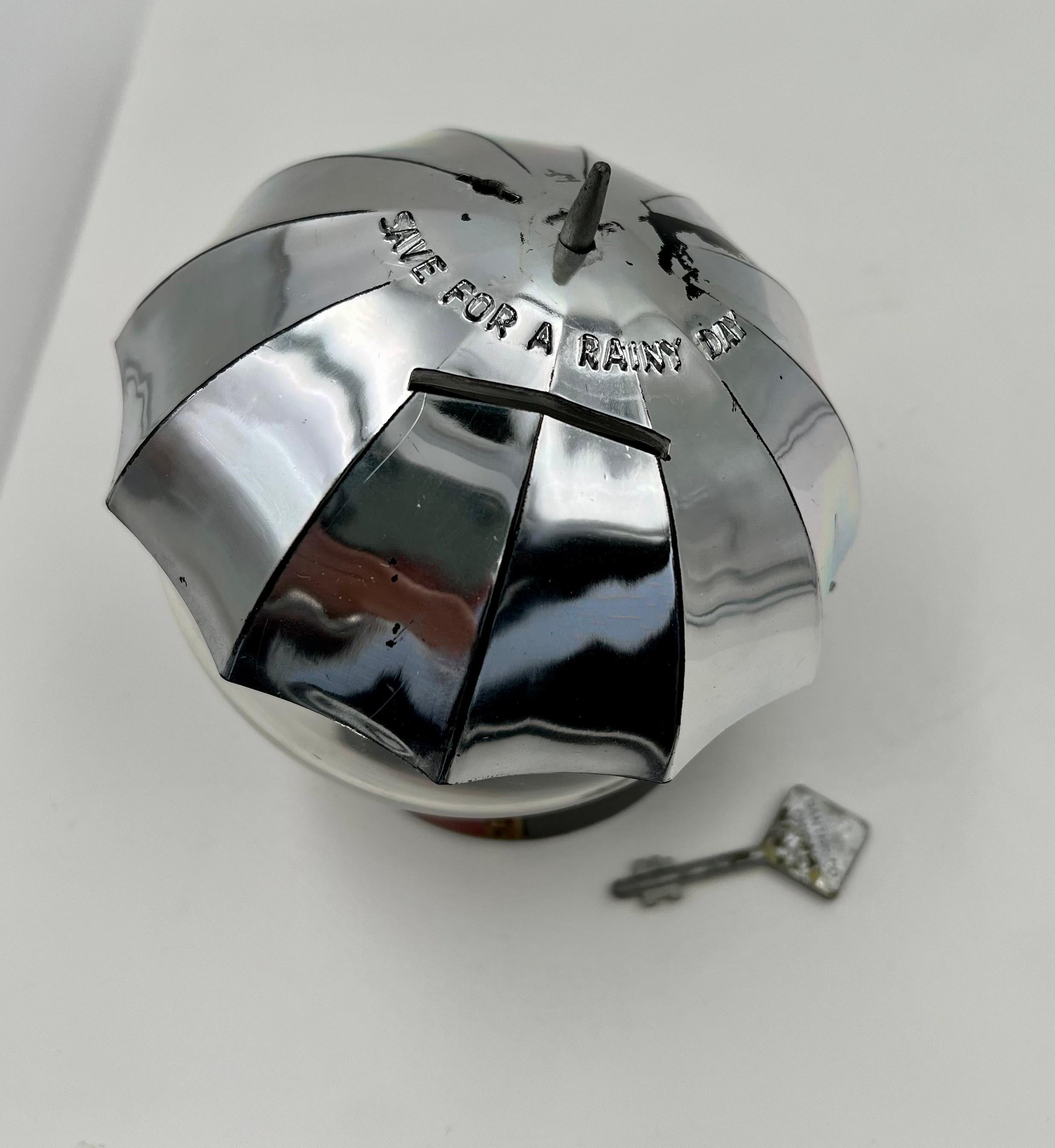 Una pieza de conversación muy chula y única, nunca se utilizó la caja original del banco paraguas y la llave para abrirlo, el cromo de la parte superior está desgastado debido a la edad pero este artículo nunca se utilizó, tiene una etiqueta de