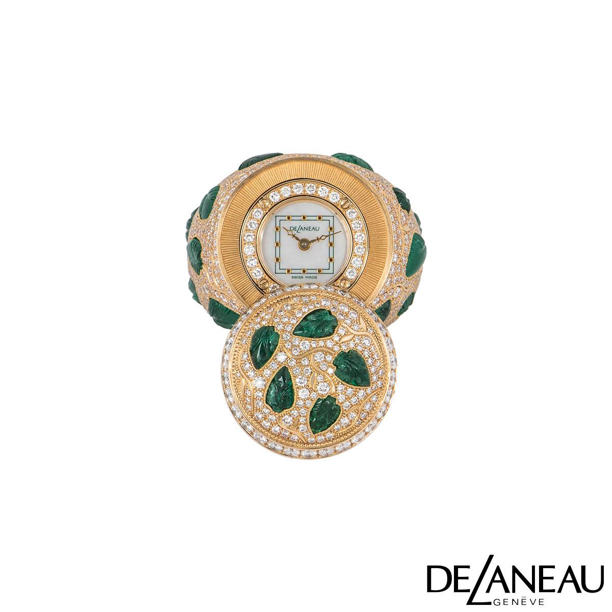 A stunning 18k rose gold ring watch by DeLanaeu from the Earth collection. The ring has a floral theme and is pave set with approximately 170 round brilliant cut diamonds alternating in sizes, with 18 emeralds carved in the shape of leaves set