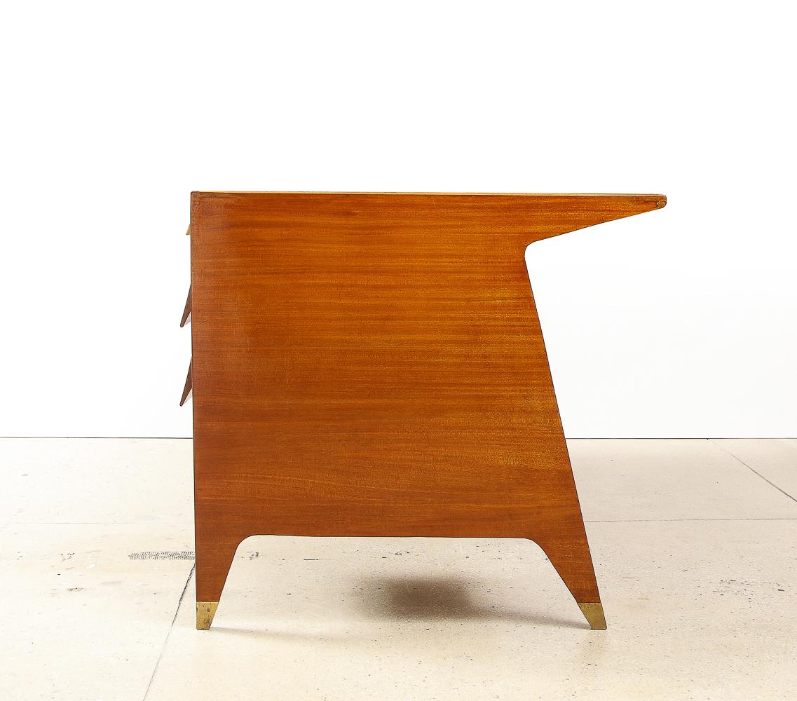 Mahogany, brass, back-painted glass. Made by Giordano Chiesa for the offices of Vembi Boroughs. Sculptural desk featuring three top locking drawers, four drawers with shaped wood handles and inset glass top. This desk has been authenticated by the