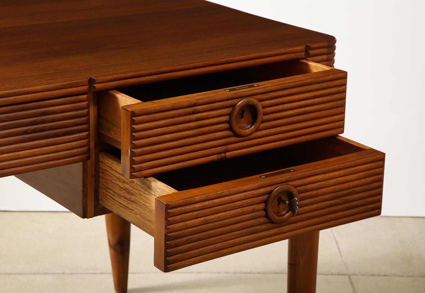 Walnut & brass. 5-drawer desk with ribbed, relief surfaces, horn legs 3 brass keys. All drawers have working lock functions.