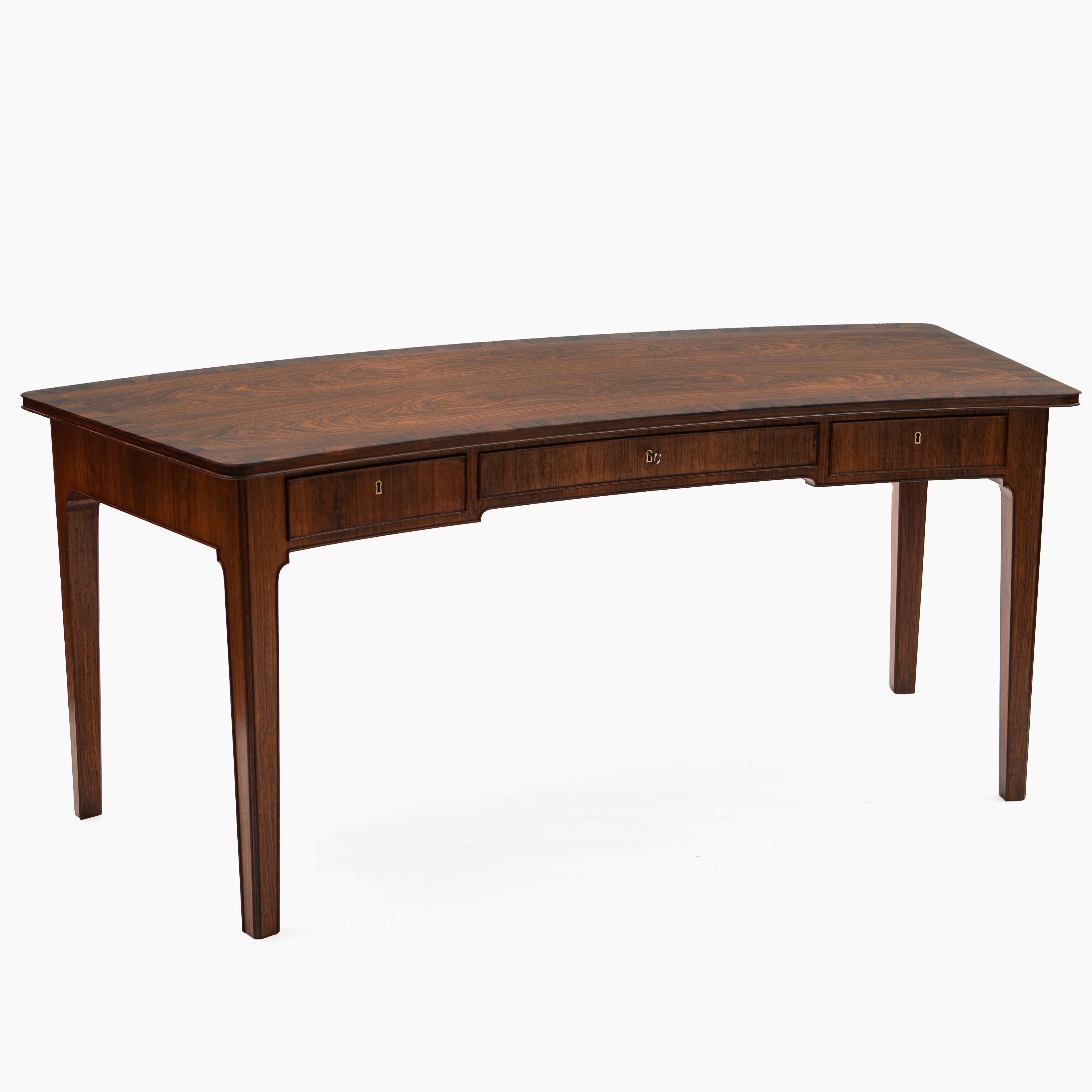 A very rare and exceptional desk made in Rio rosewood. Likely to be one of a kind, made by cabinetmaker C.B. Hansen, labelled accordingly.
The desk features an elegant and unique crescent silhouette and gorgeous rosewood grain.
Table top with a