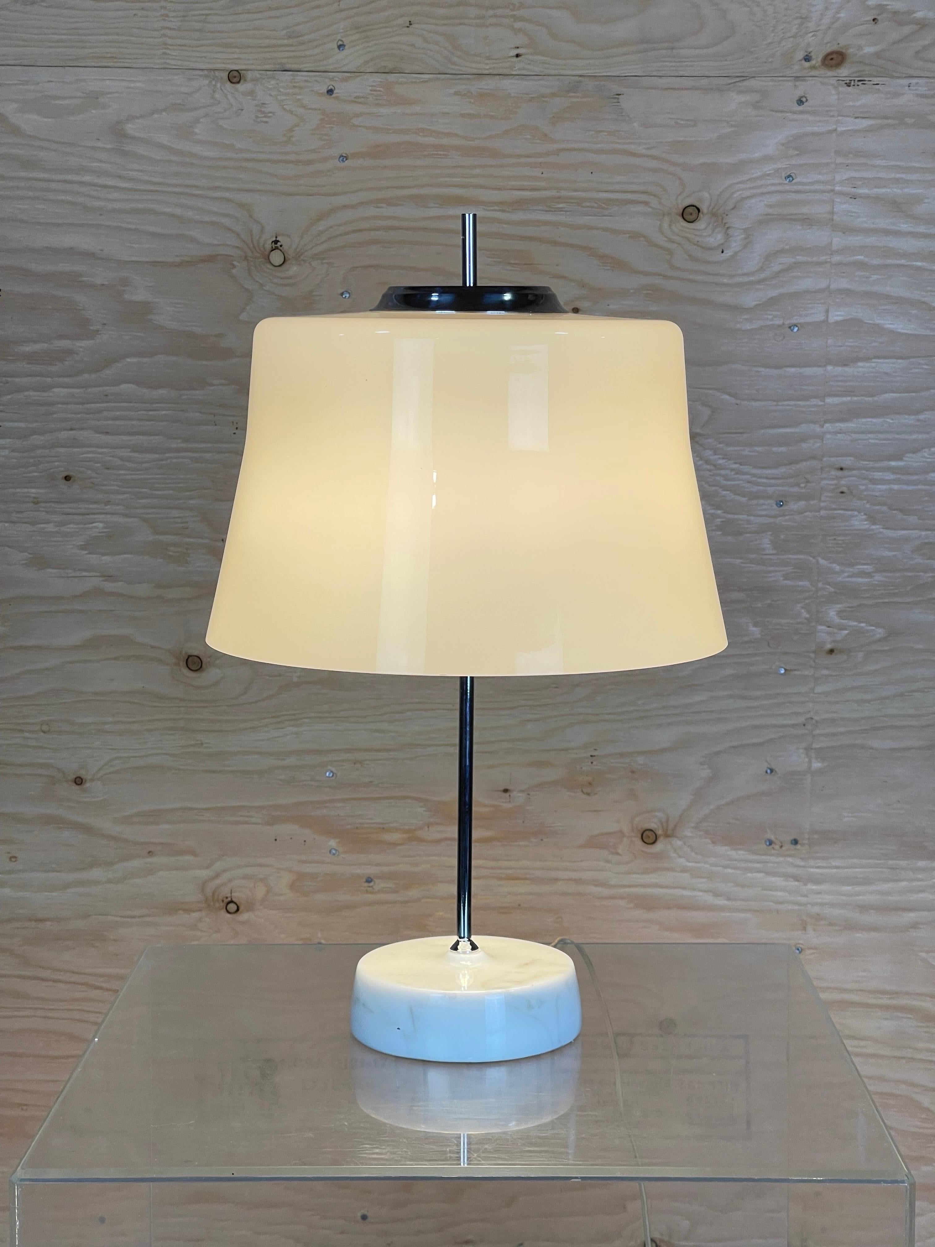 Beautiful and rare table lamp atttributed Angelo Lelli for Arredoluce. The light consists of a round thick marble base which curves right up to the chrome base. The grey glass draped shade is made of two layers of handblown glass. The grey toned