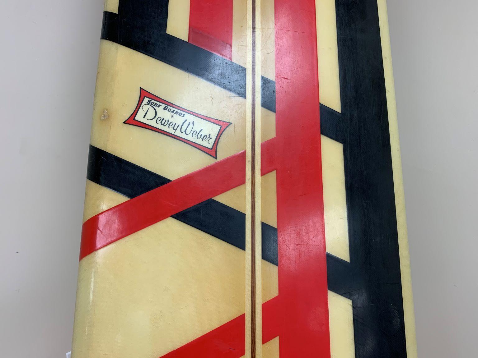 Vintage Dewey Weber surfboard with an amazing black and red stripe pattern. Dewey Weber Brand tag is still intact. The board does have a fiberglass repair on the bottom side (see photo) as a previous owner installed a bracket so it could be hung on