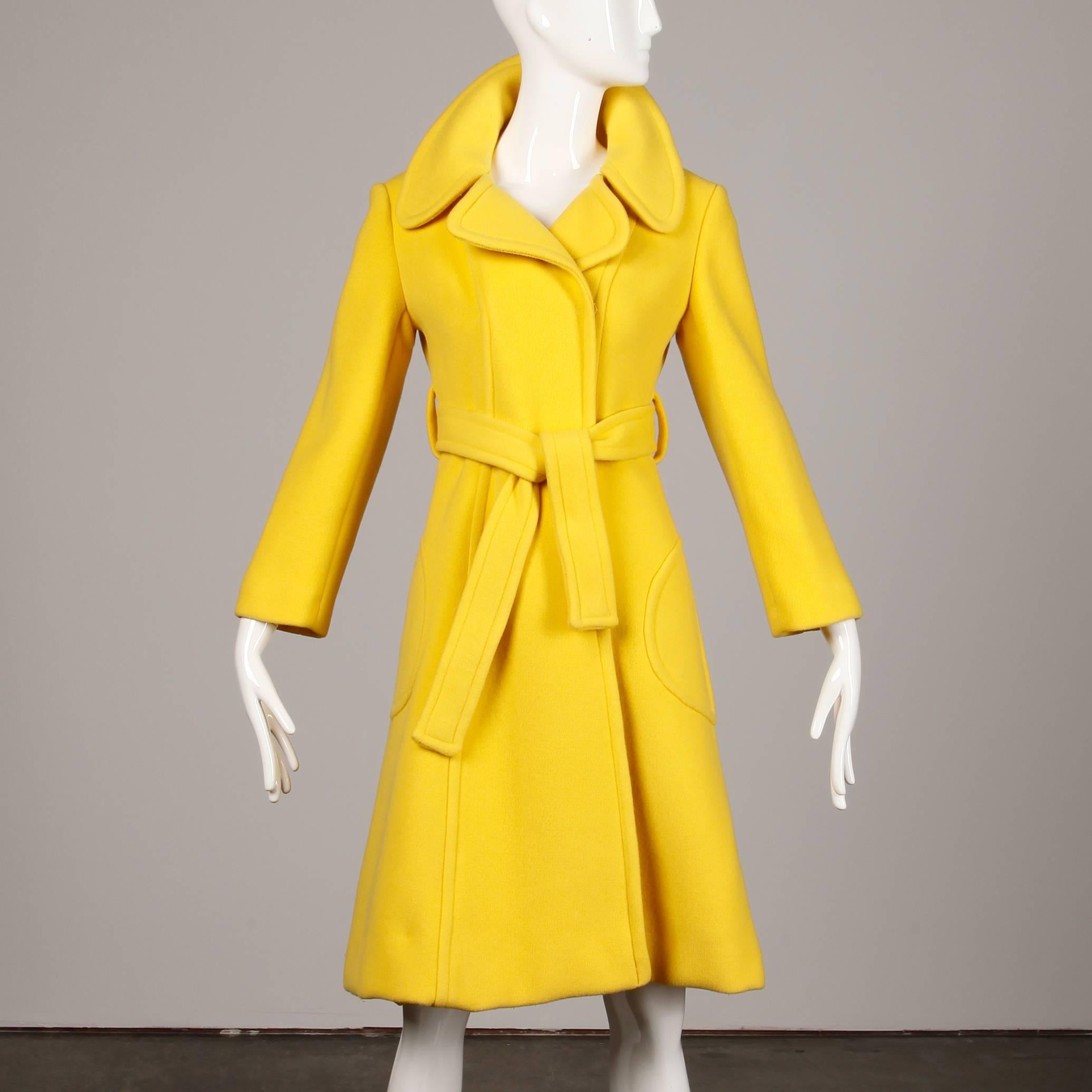 Stunning vintage 1970s yellow wool coat by Dia Diodato with a matching waist sash and rounded pop up collar. Fully lined with front snap and tie closure. Front patch pockets. Fits like a modern size small. The bust measures 35.5