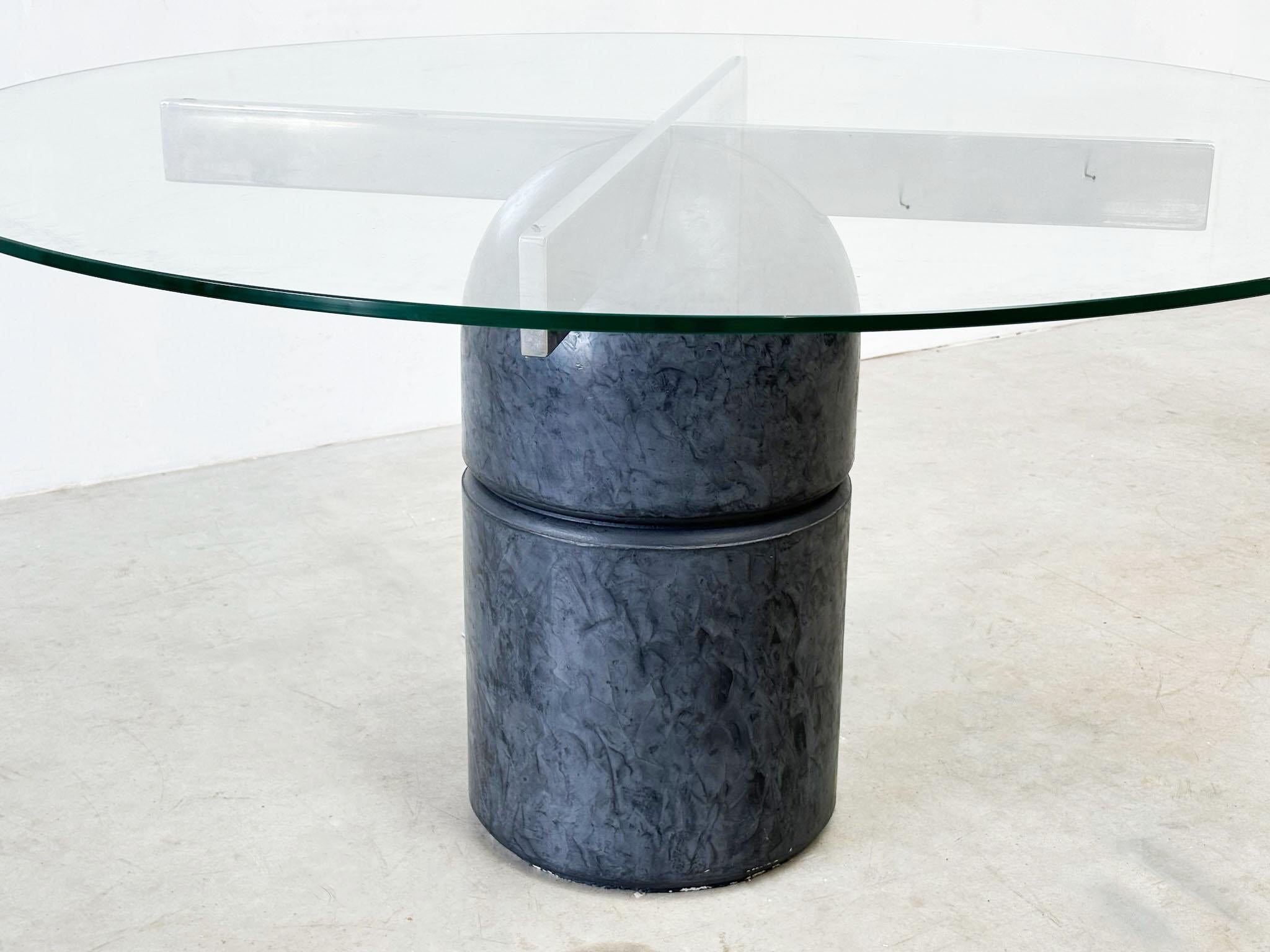 Beautiful brutalist but elegant dining table by Giovanni Offredi for Saporiti.

This table was made in the late 70's. This particular table is model Paracarro.

It features a heavy cermic black concrete base and a thick round glass top.

The table