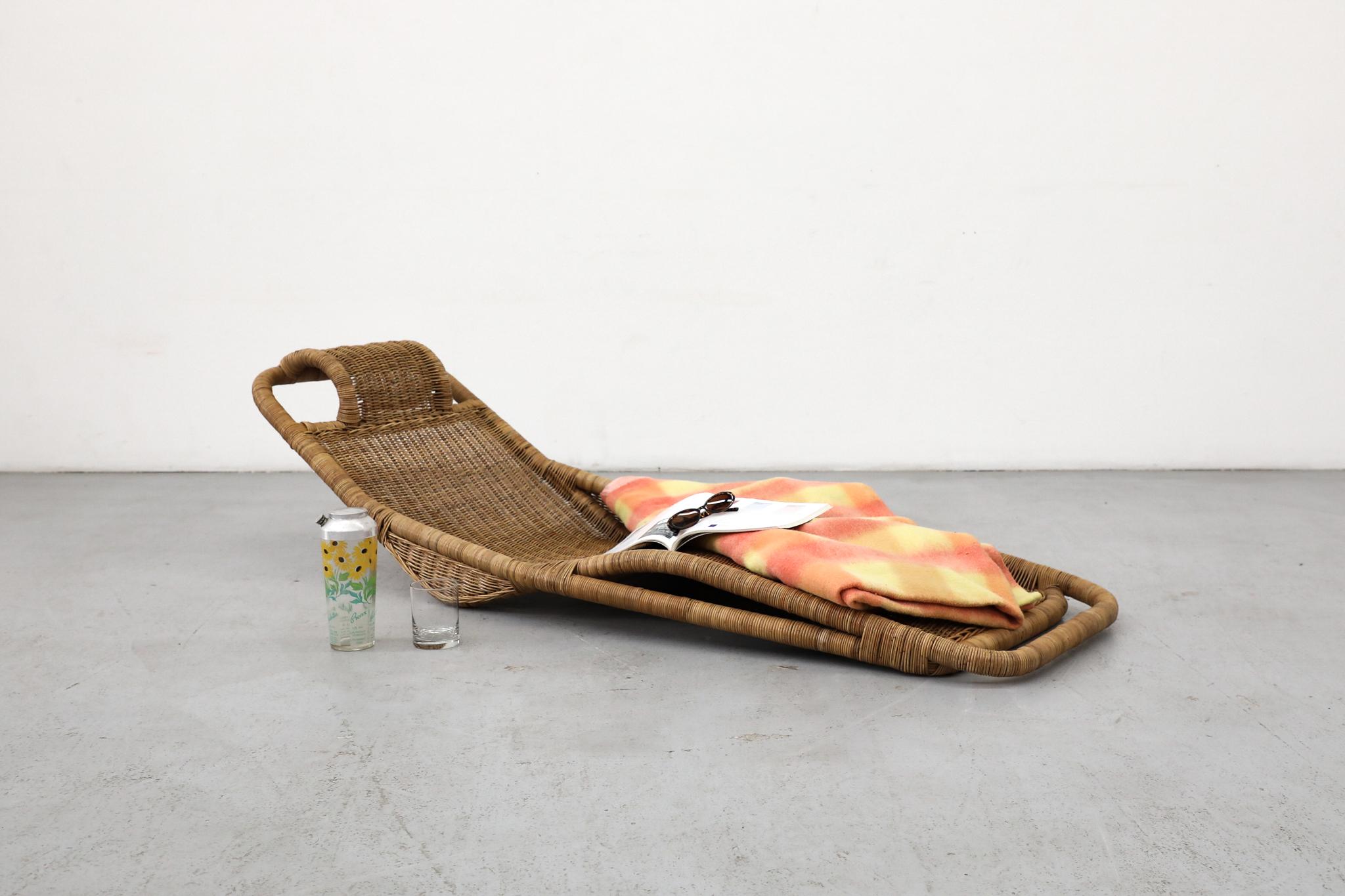 Rara y cautivadora pieza del diseño holandés de mediados de siglo, esta chaise lounge de ratán se atribuye al célebre diseñador Dirk Van Sliedregt para el fabricante Gebroeders Jonkers. Esta versión única, apoyada en el suelo, se distingue de los