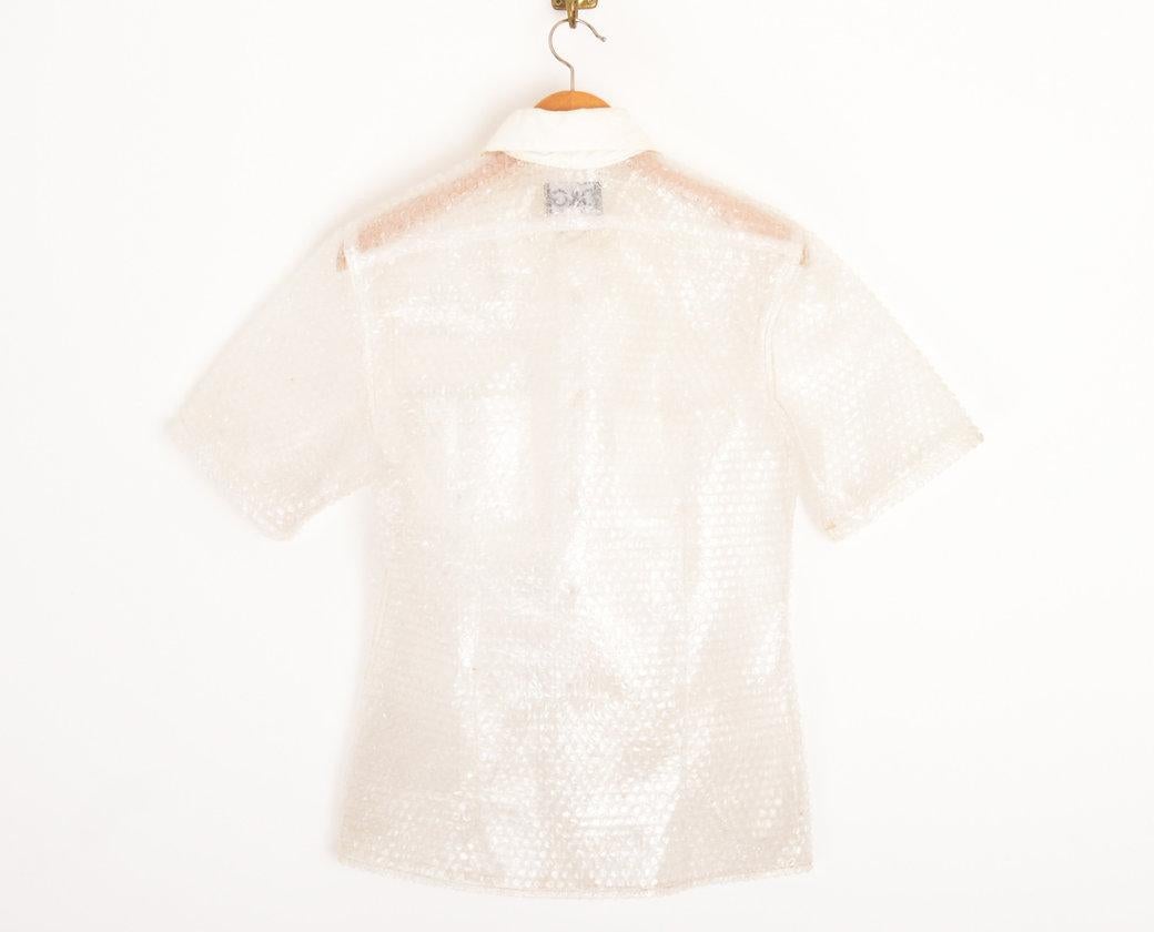 DOLCE & GABBANA 'BUBBLE WRAP' SHIRT
1990's
 
Rare 1990's Dolce & Gabbana experiemental 'Bubble Wrap' shirt. Short sleeves with off white polyester collar & breast pocket details. 
 
Features;
Central line button fasten
Bubble Wrap construction
