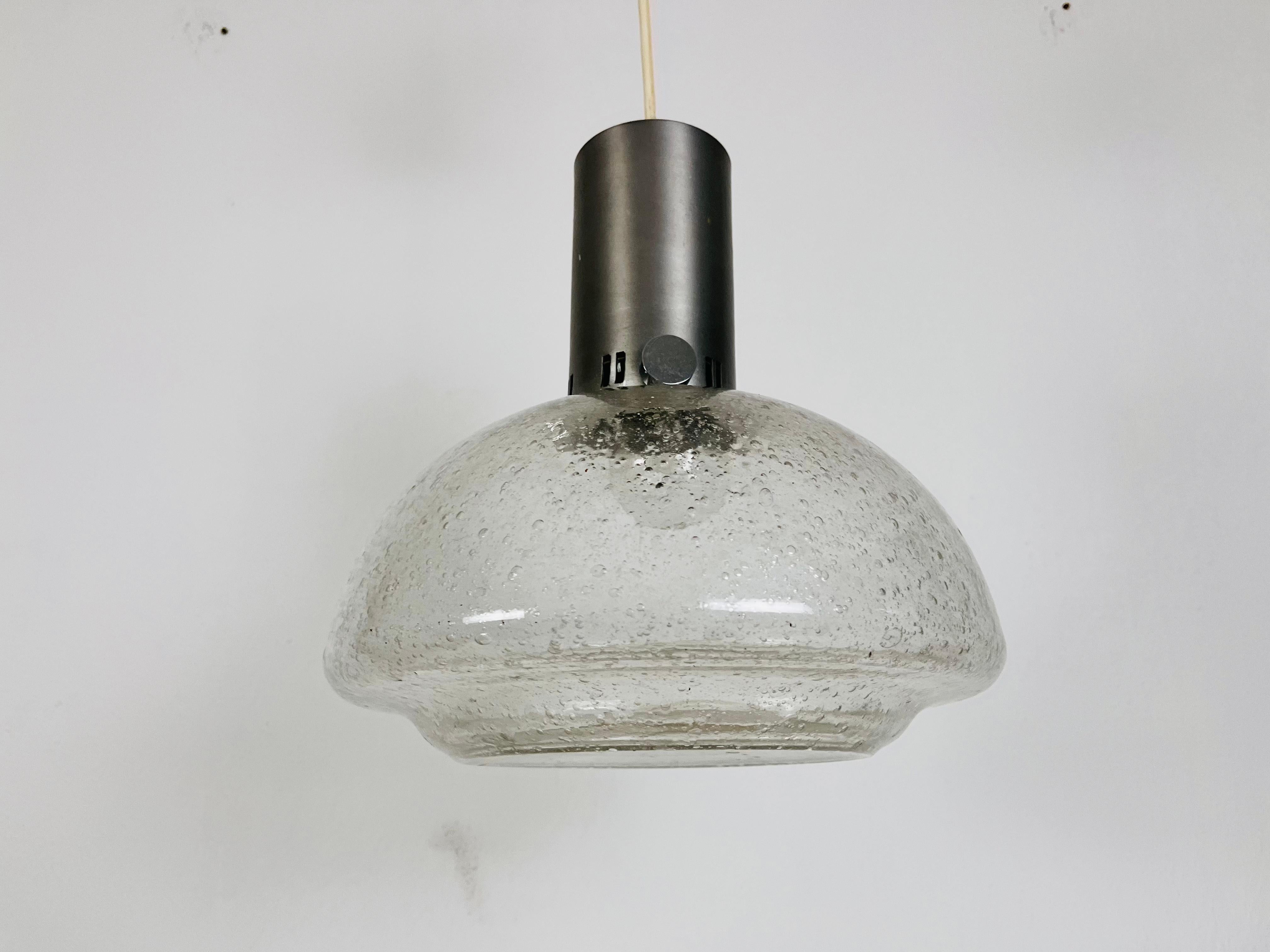 A Doria ice glass pendant lamp made in Germany in the 1960s. It is fascinating with its rare glass shape. 

Measurements: 
Height: 32-60 cm
Dia: 30 cm

The fixture requires one E27 light bulb. Works with both 120/220V. Good vintage