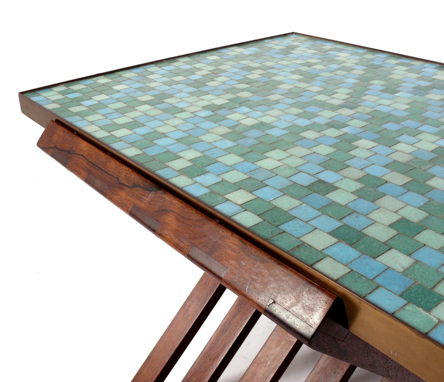 Rare Italian glass mosaic tile top table, designed by Edward Wormley for Dunbar, circa 1950s. Executed in an Italian glass mosaic tile top banded in brass, with a rosewood campaign style X folding base. Signed with manufacturer's label underneath.