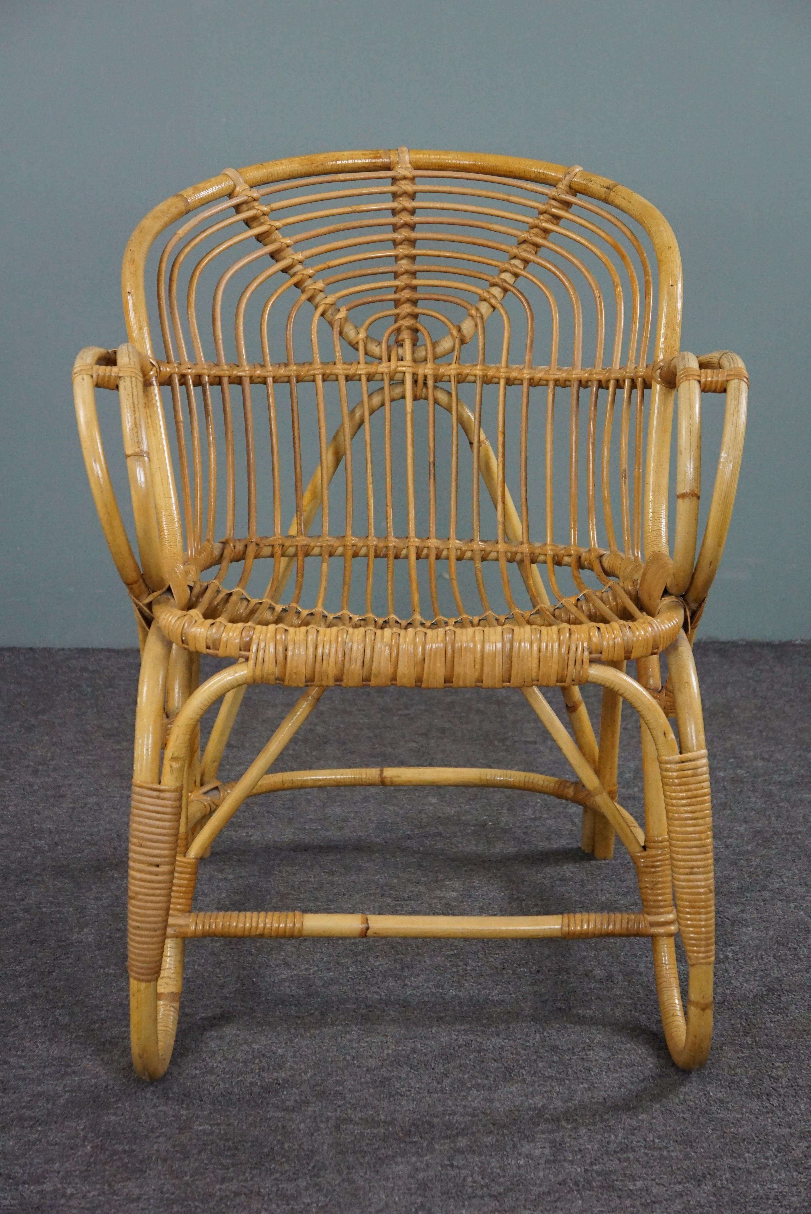 Offered is this unique and very beautifully designed armchair made in the 1950s in the Netherlands.
This rare rattan armchair has a beautiful subtle design and beautiful round details and graceful armrests and legs. This armchair was handmade in the