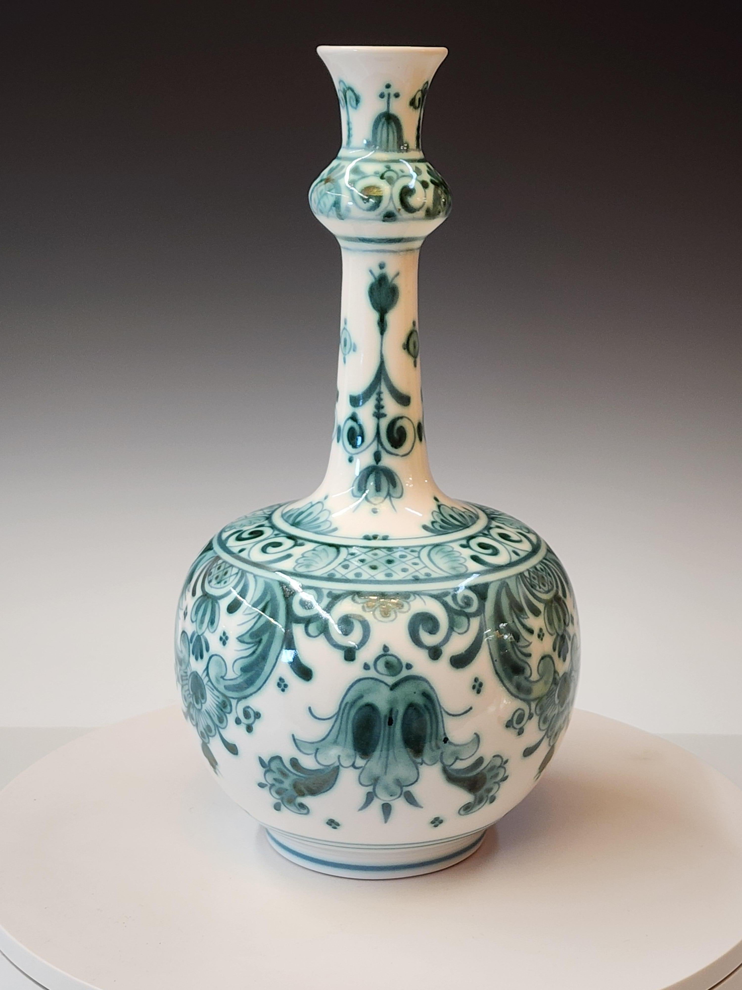 Questa rara bottiglia/vaso in terracotta smaltata a stagno, un Fles giapponese, è decorata in tonalità di verde tenue con motivi geometrici. Rifinito con uno smalto lattiginoso e lucido. Firmato sul fondo in verde sottosmalto per De Porceleyne -