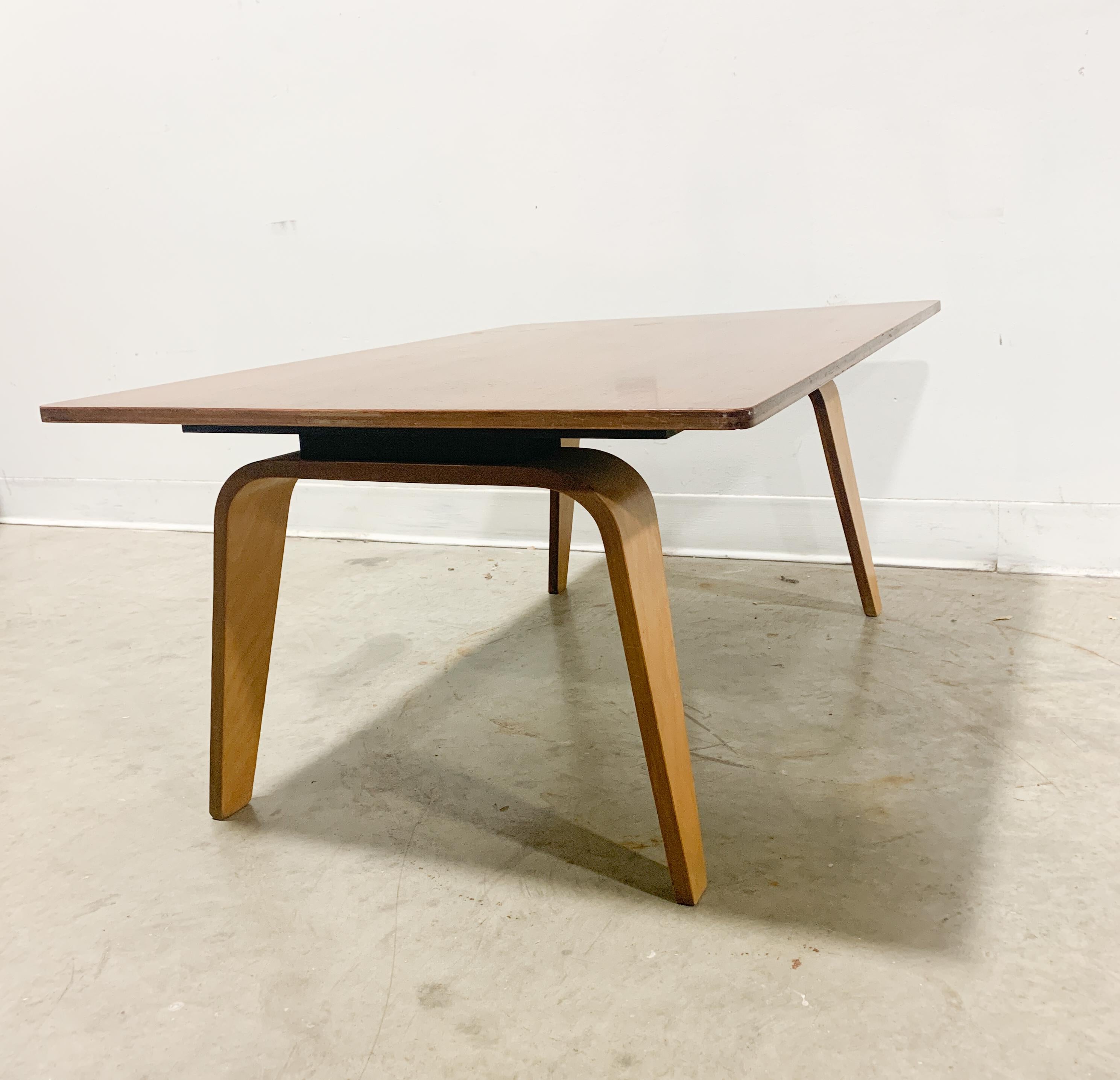 This is a rare and highly collectible Eames table model OTW (Oblong Table Wood) probably made by Evans Products pre-Herman Miller. Designed in 1946 by Charles and Ray Eames, the Walnut top is 5 plys, the black sub frame is nailed on, and the legs