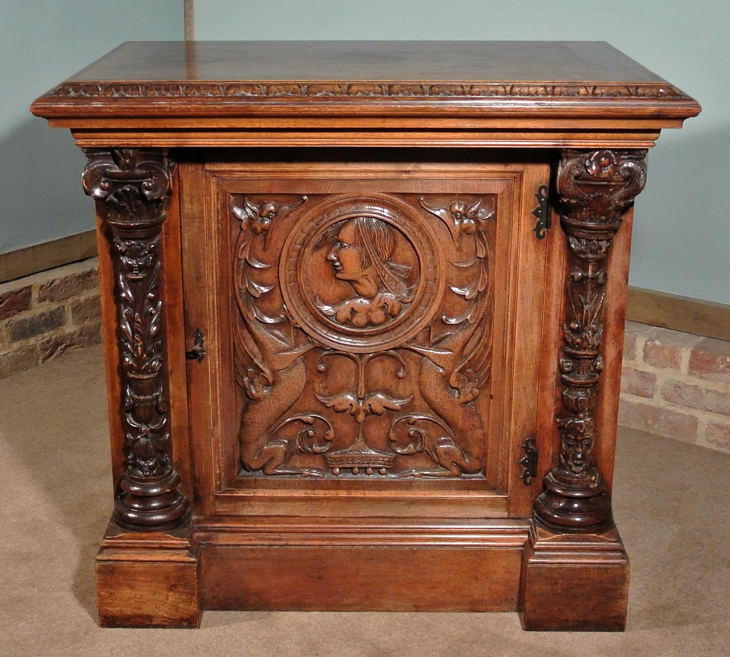 An unusual 19th century solid walnut cupboard incorporating four 16th century carved elements, possibly taken from a Late Medieval Aumbry and including an exceptionally rare and important early 16th century carved walnut panel featuring a pair of