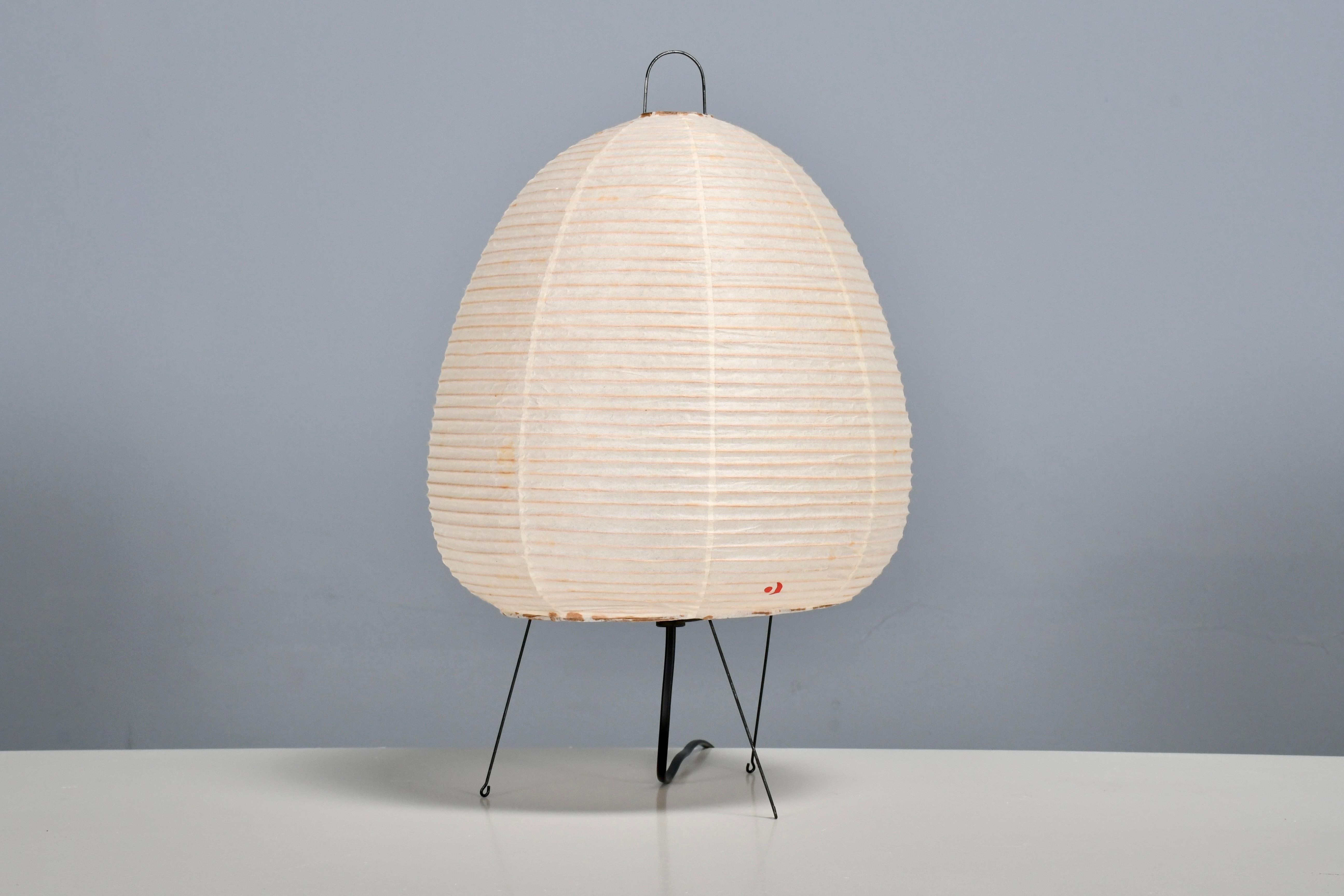 Early 1A Akari table lamp in excellent condition.   

Designed by Isamu Noguchi in 1951 Produced by Ozeki & Co., Ltd.   

New old stock, original packaging.

Model 1A is a table lamp with a metal frame and an oval shaped shade from the Akari series.