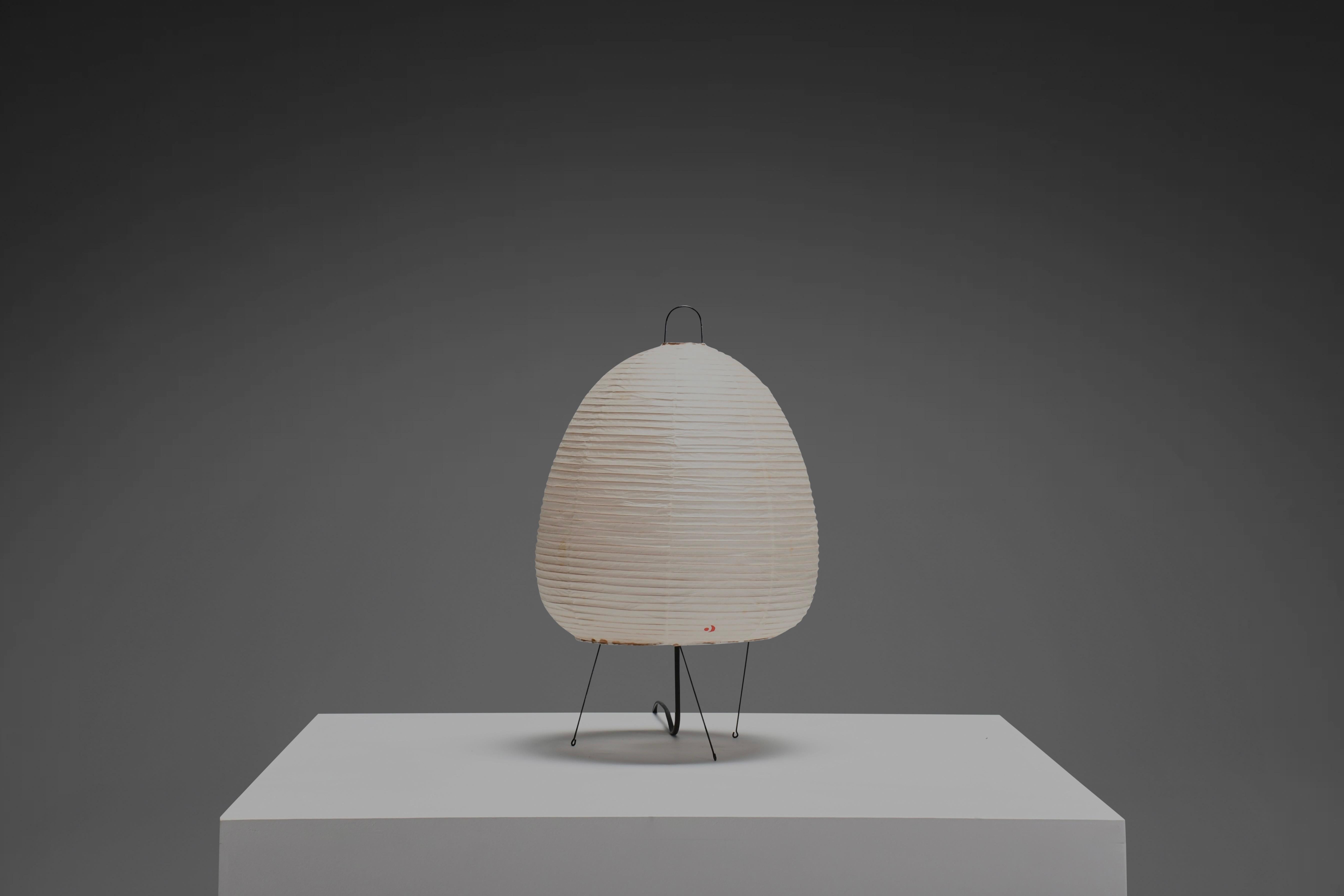 Early 1A Akari table lamp in excellent condition.   

Designed by Isamu Noguchi in 1951 Produced by Ozeki & Co., Ltd.   

New old stock, original packaging.

Model 1A is a table lamp with a metal frame and an oval shaped shade from the Akari series.
