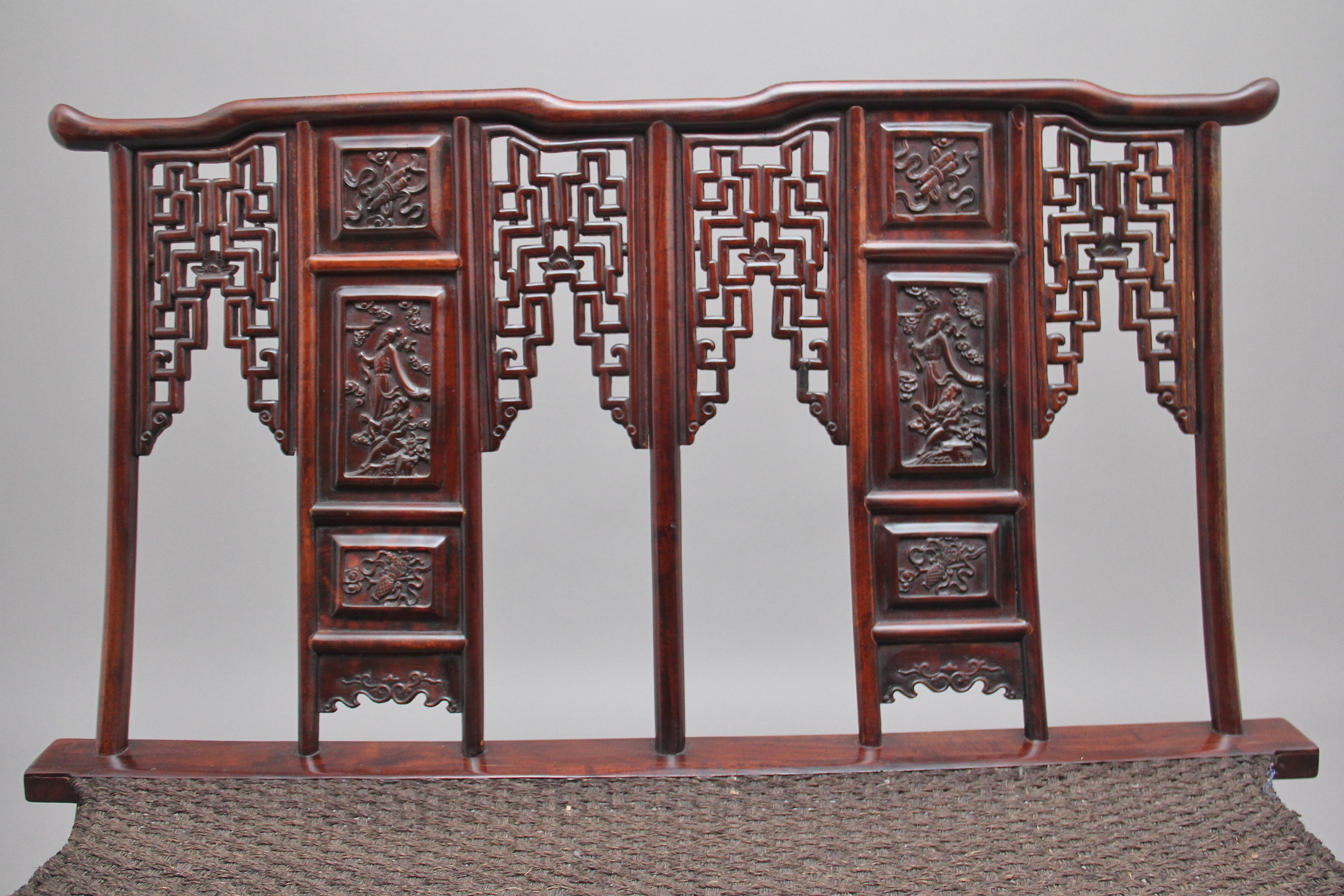 A very rare early 20th century Chinese hongmu folding officials chair from the late Qing dynasty, having a traditional Chinese shaped top rail, carved fret decoration either side of the central splat back with carved portrait panels, a well fitted
