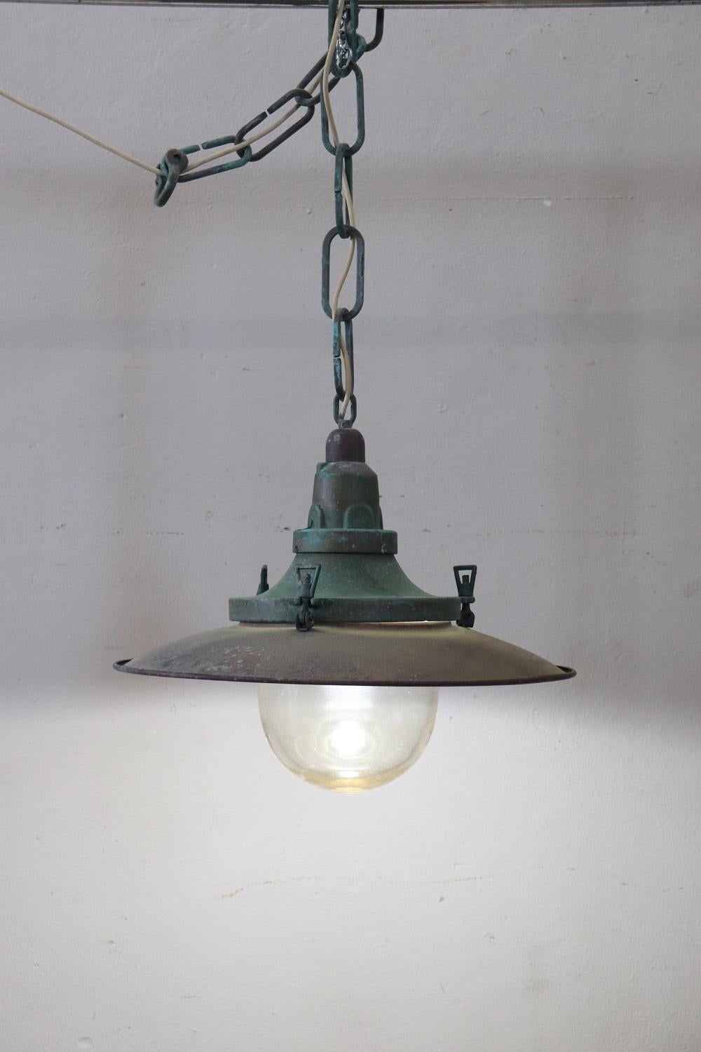 This old nautical pendant lamp from around 1920s is truly rare. Made of copper with a very thick glass that protects the bulb. The copper has oxidized over time and acquired this beautiful vintage patina. This pendant lamp can be changed in its