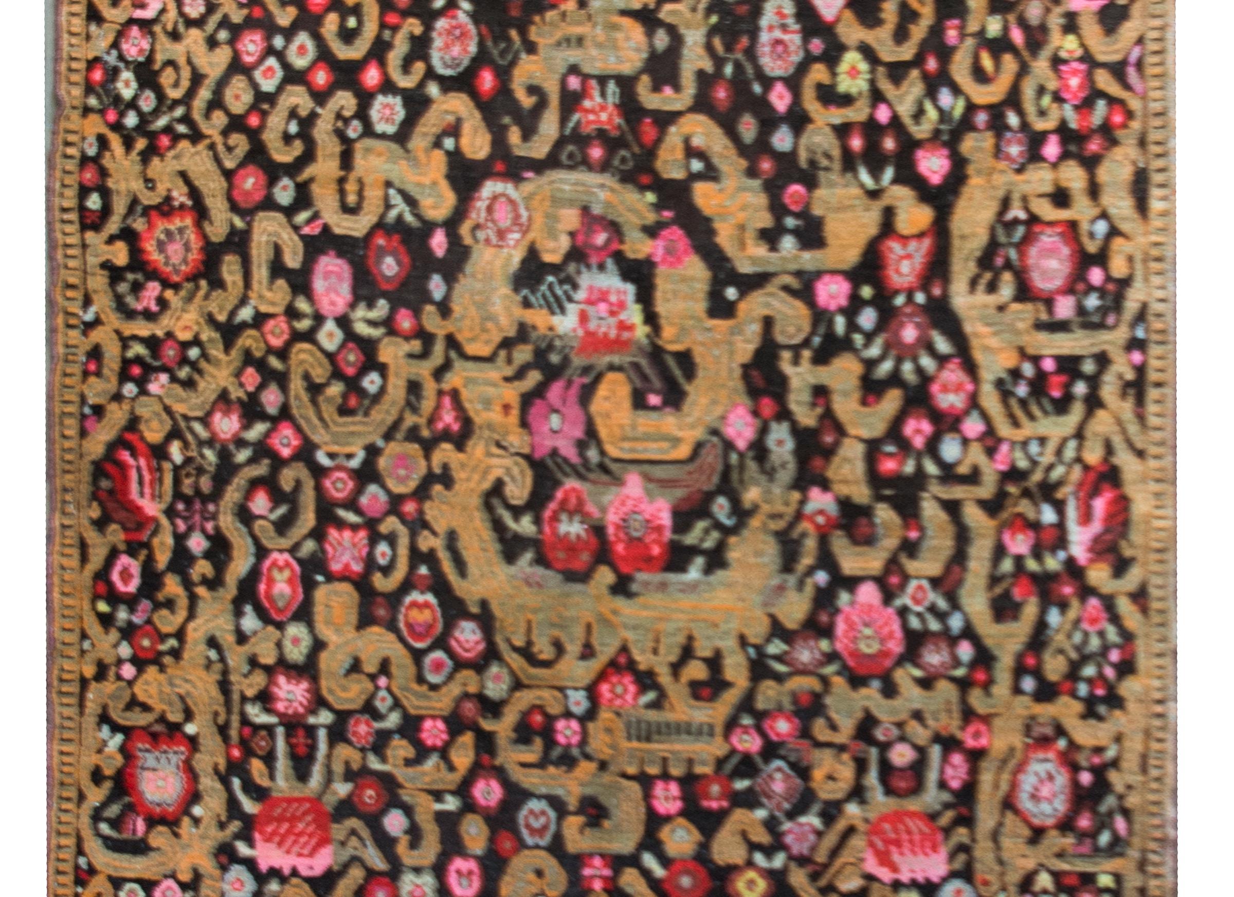 The most incredible and rare early 20th century Persian Kareback rug with a lively pattern of myriad stylized flowers, leaves, and scrolling vines, all woven in crimson, pink, white, gold, and green, and set against a black background.  We've not