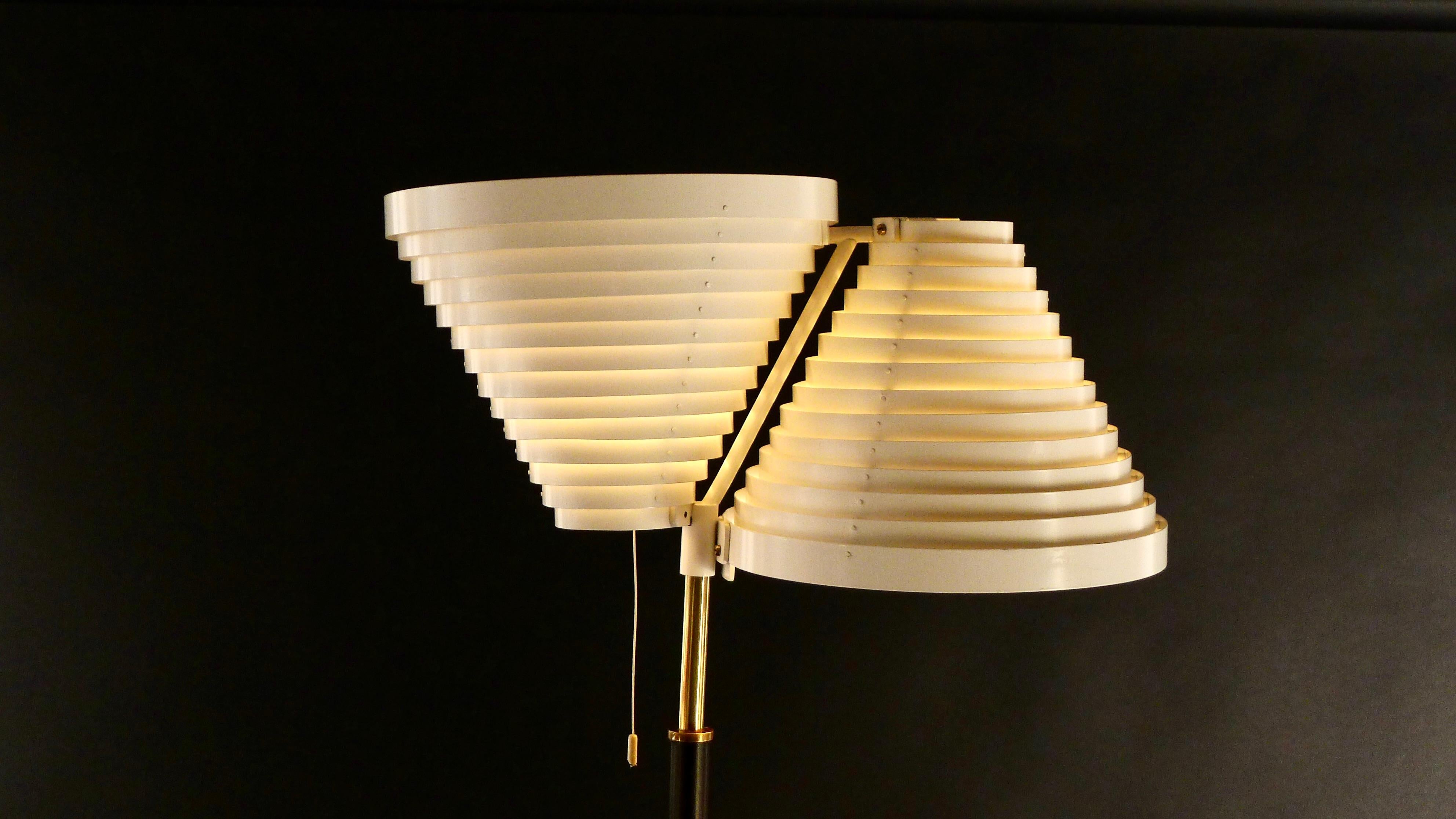 This is rare early Double Angel Wing floor lamp was designed by Alvar Aalto in 1959 and produced by Valaistystyo Ky, Helsinki, who were the first manufacturers of the lamp.

The iconic white lacquered metal louvred shades rise from a leather covered