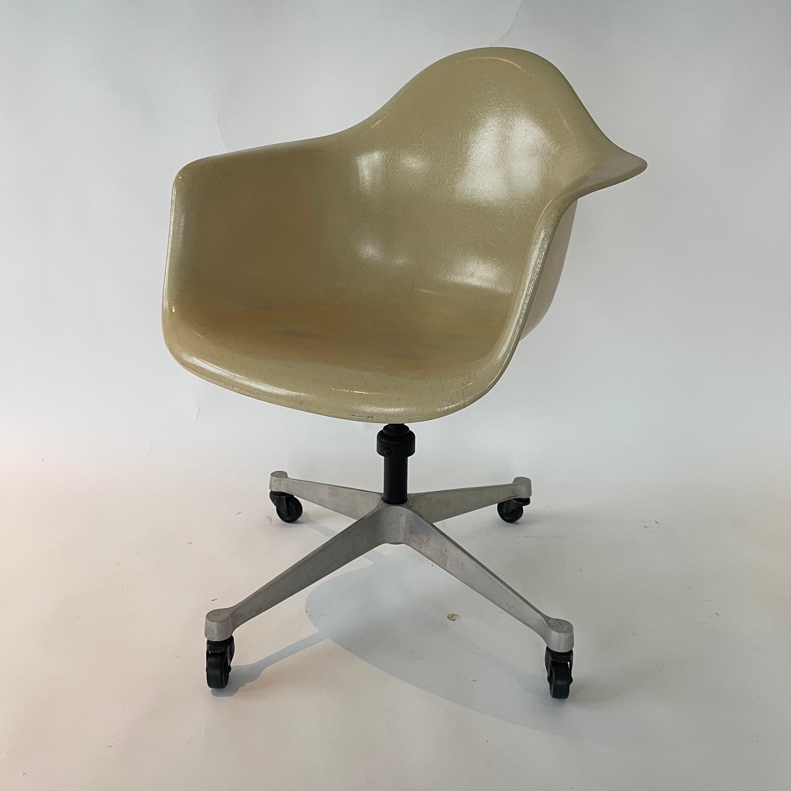 Rare early PACC (Pivoting Arm Chair on Cast base with Castors), rendered in a molded one piece fiberglass shell for chair seat back and arms, with a cast aluminum spider base with castors.  Designed by Charles and Ray Eames for Herman Miller, USA,