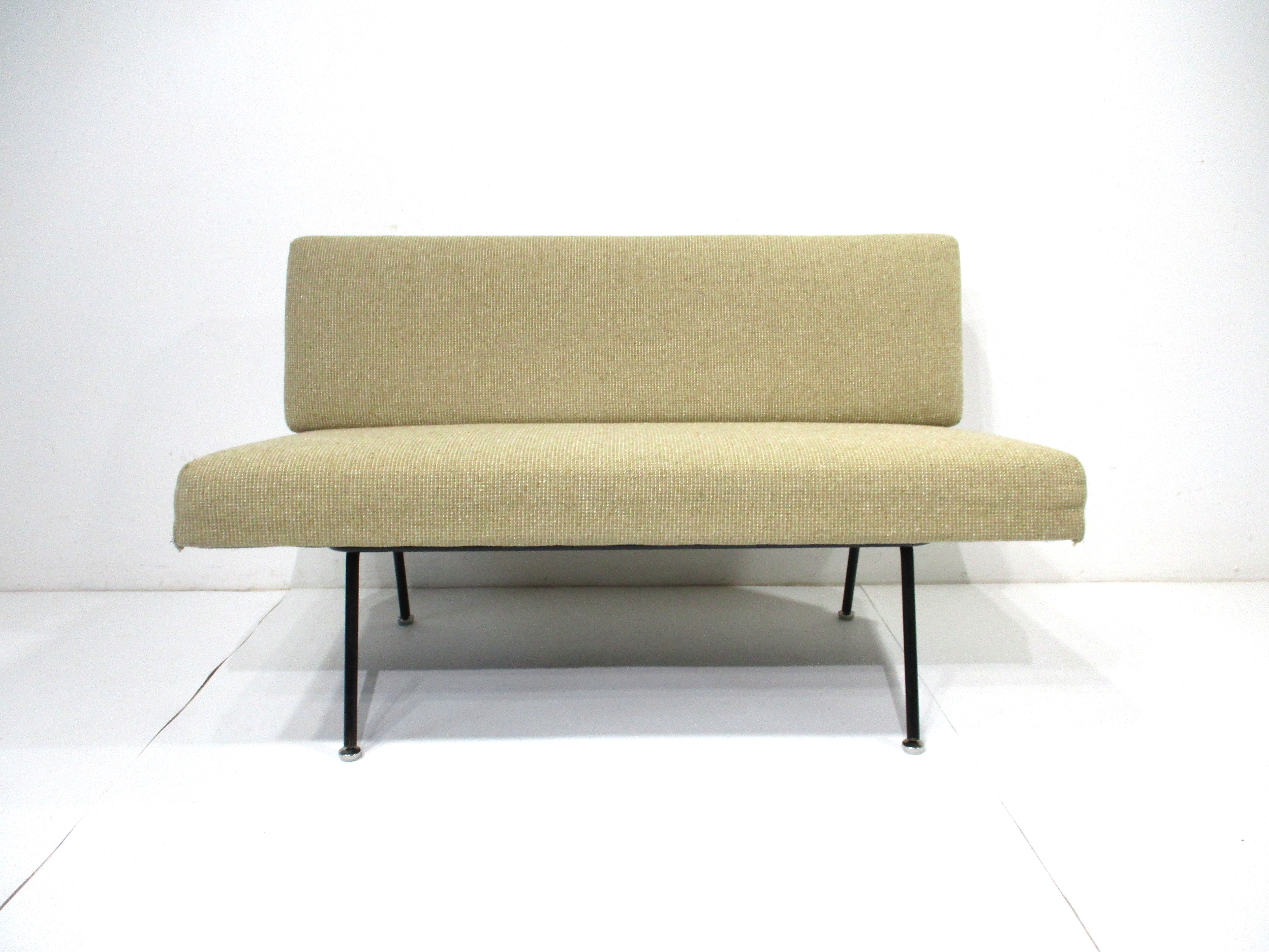 A rare tubular satin black steel framed based settee with oatmeal colored upholstery . Great for a smaller space or an area where you want to keep things simple and light , the sofa is very comfortable and accented with pillows even more so . The