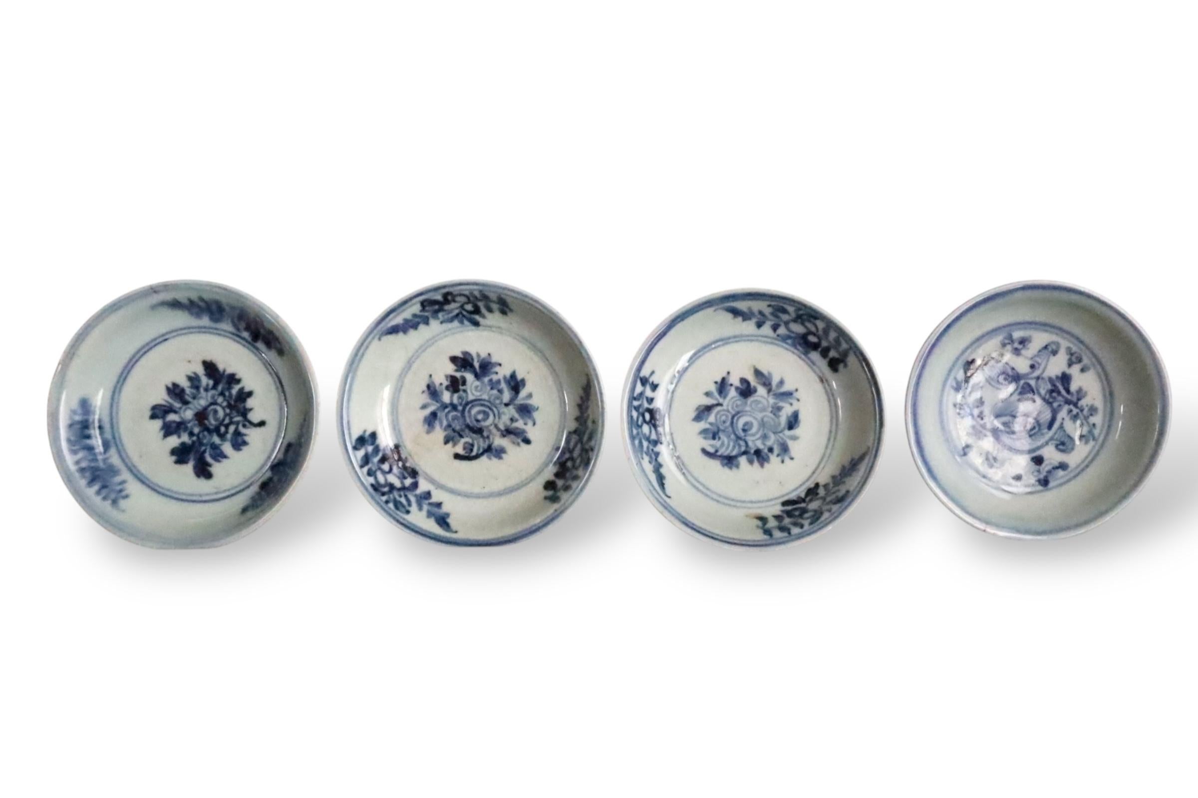 A fine group of early Ming dynasty (c. 15th century) porcelain dishes, hand-painted in cobalt blue underglaze with floral and foliate motifs. These plates were found in Japan, where Chinese porcelain from the Ming period was highly valued during the