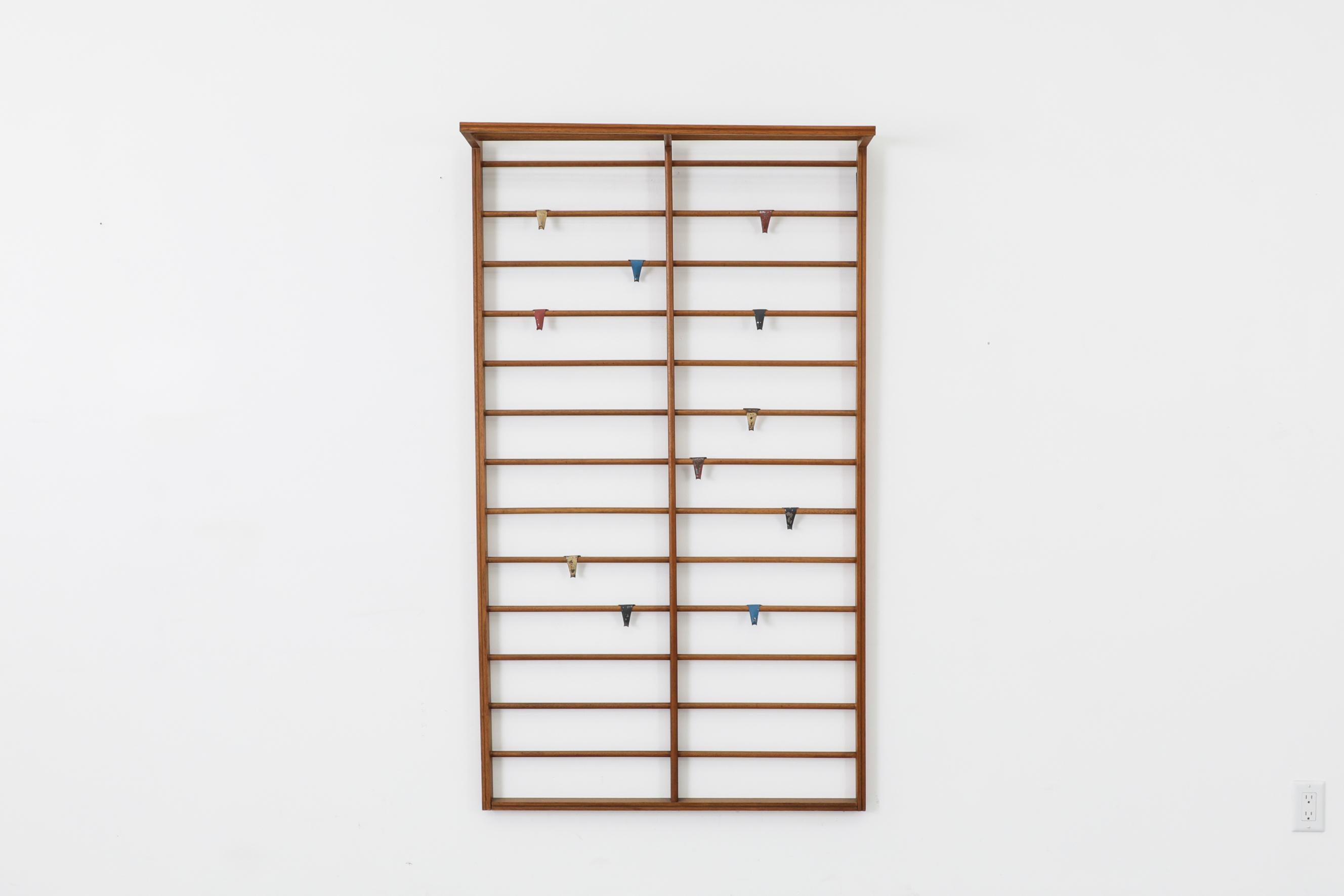 Rare early Pilastro teak coat rack teak with movable metal enameled hooks. A rare find, these commonly are found with an enameled metal frame. This is the 1st wall mount coat rack that we have ever come across that's made of wood. In original