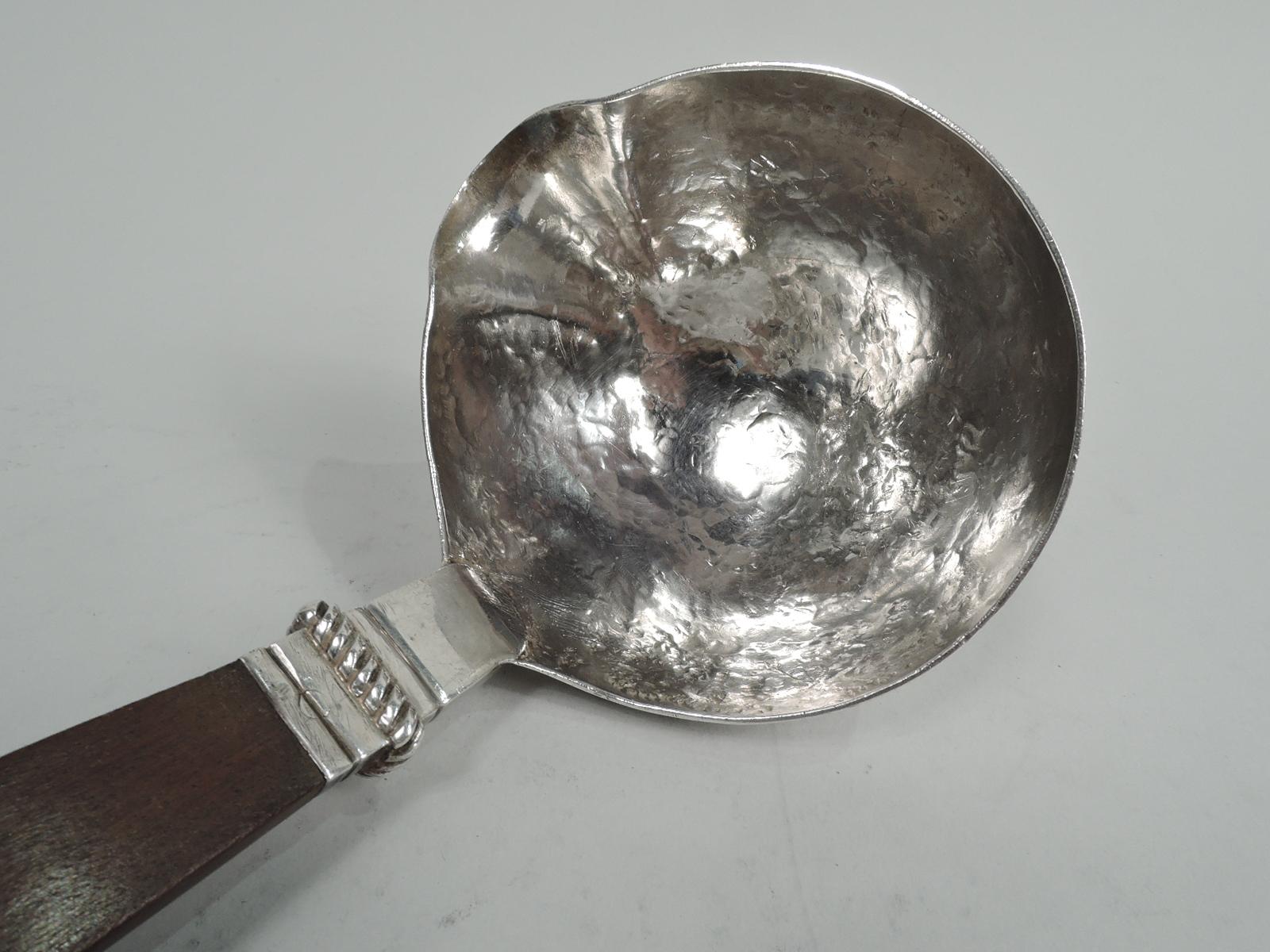 Rare sterling silver punch ladle. Made by Spratling in Taxco, Mexico. Round hand-hammered bowl with curved spout. Mount has tooled bands and applied rope band and is inset with tapering stained-wood handle. An early piece by this maker. 1940s marks.