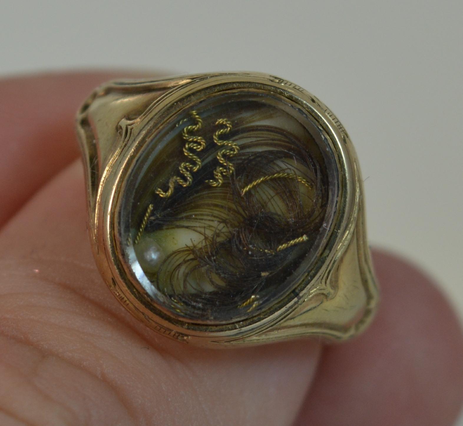 A highly unusual and rare early Victorian period ring.
SIZE ; Q UK, 8 US
Signet mourning ring design with braided hair locket section to the front. 11mm x 13.5mm approx. 
Fine pattern surrounding and to shoulders. All modelled in 18 carat yellow