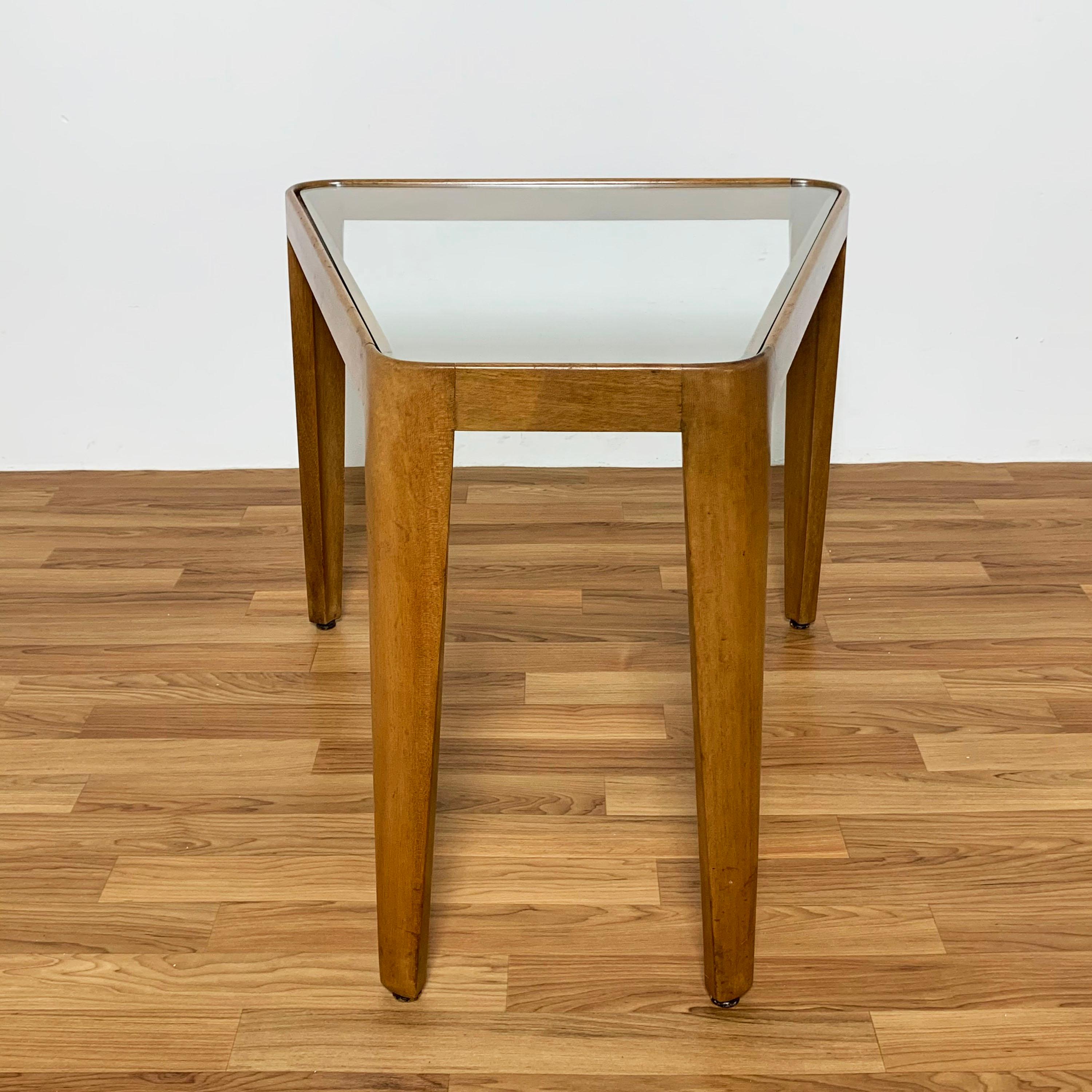 An uncommon early trapezoidal wedge shape side table in mahogany with glass top by Edward Wormley for Dunbar, ca. 1948. Model number 4809.