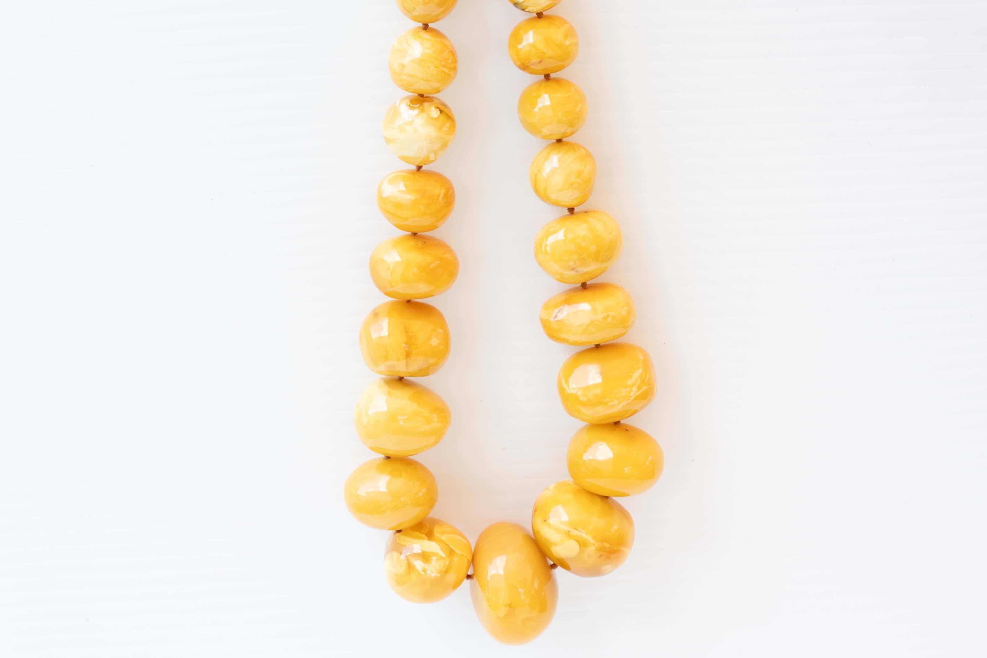 Rare colossal-sized baltic amber in an exceptional egg yolk colour. Measures 26 inches long, made of 31 beads from 14.5mm in diameter to 42mm, not perfectly round, for a total weight of 237 grams. The biggest beads measure 42 x 29mm and 37 x 28.5