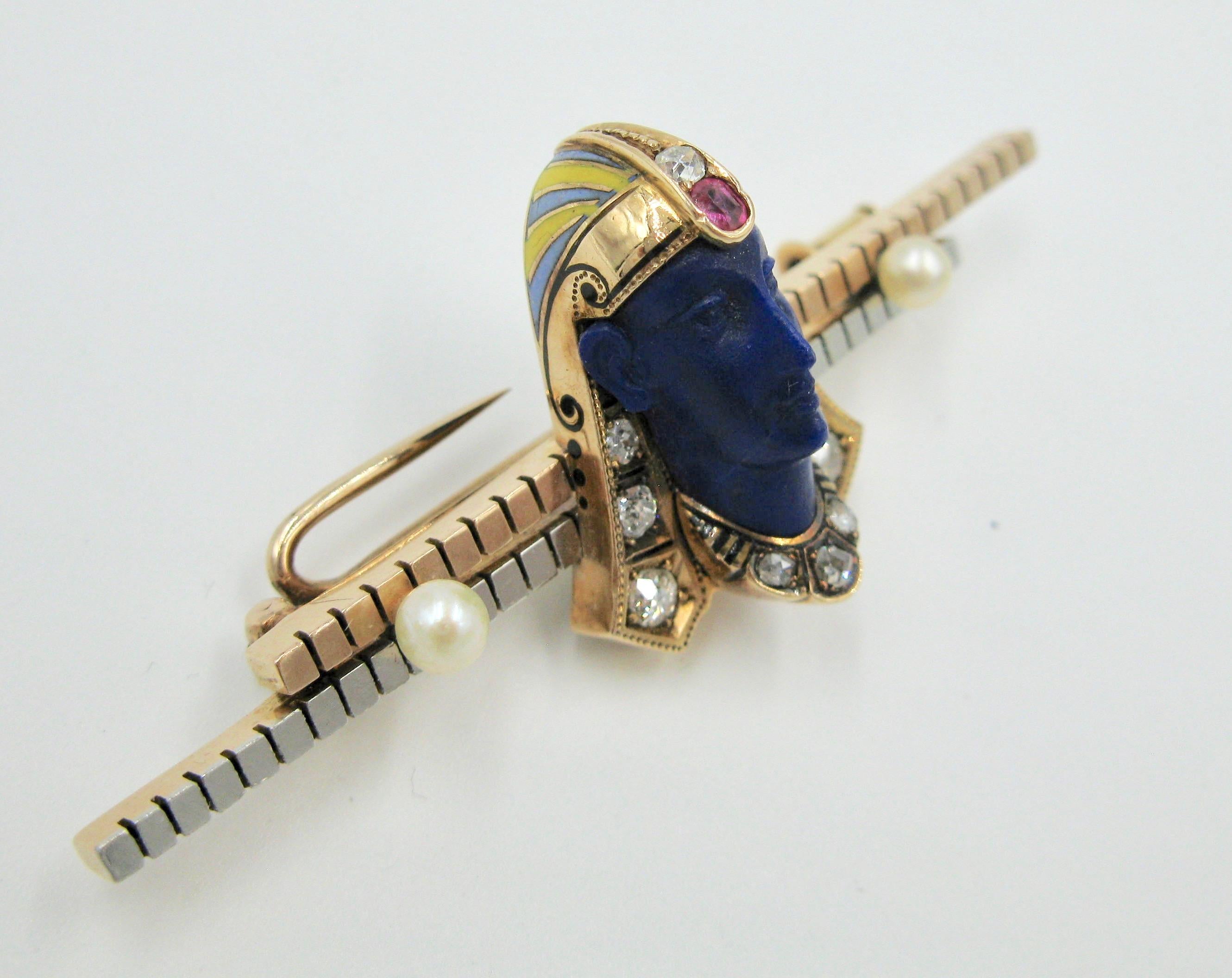 This is a museum quality Belle Epoque - Art Deco Egyptian Revival masterpiece with a Lapis Lazuli Pharoah, adorned with Old Mine and Rose Cut Diamonds, Ruby, and Pearls and set in 14 Karat Bi-color Gold with yellow, blue and black enamel.  The