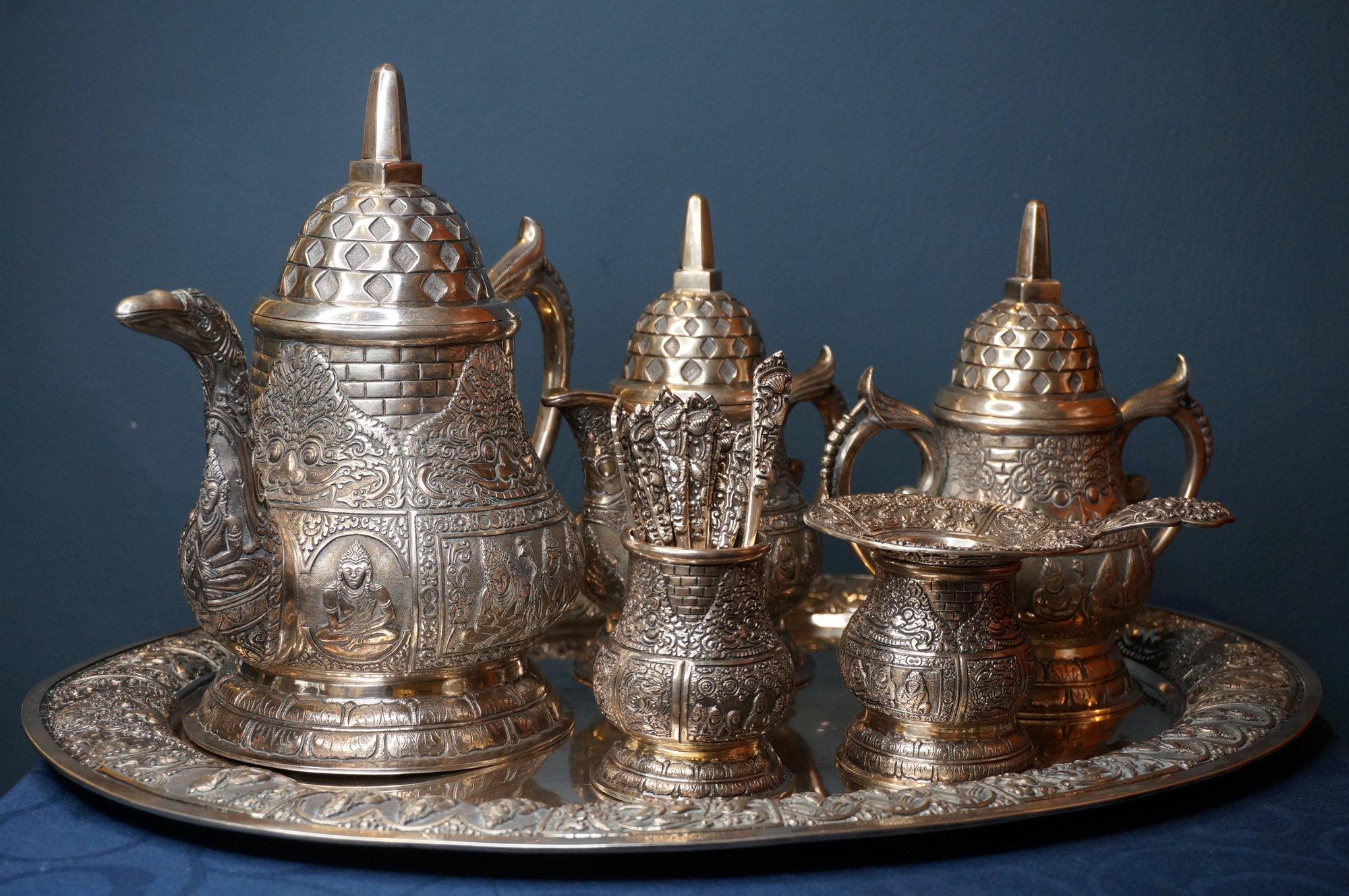 Rare elaborately decorated Jogja tea service with unusual decoration of boddhisatva, taotie masks, birds and pagoda-shaped lids. The tea service contains a teapot, coffeepot, sugarbowl, vase with 12 teaspoons and 1 sugar spoon and a vase with a tea