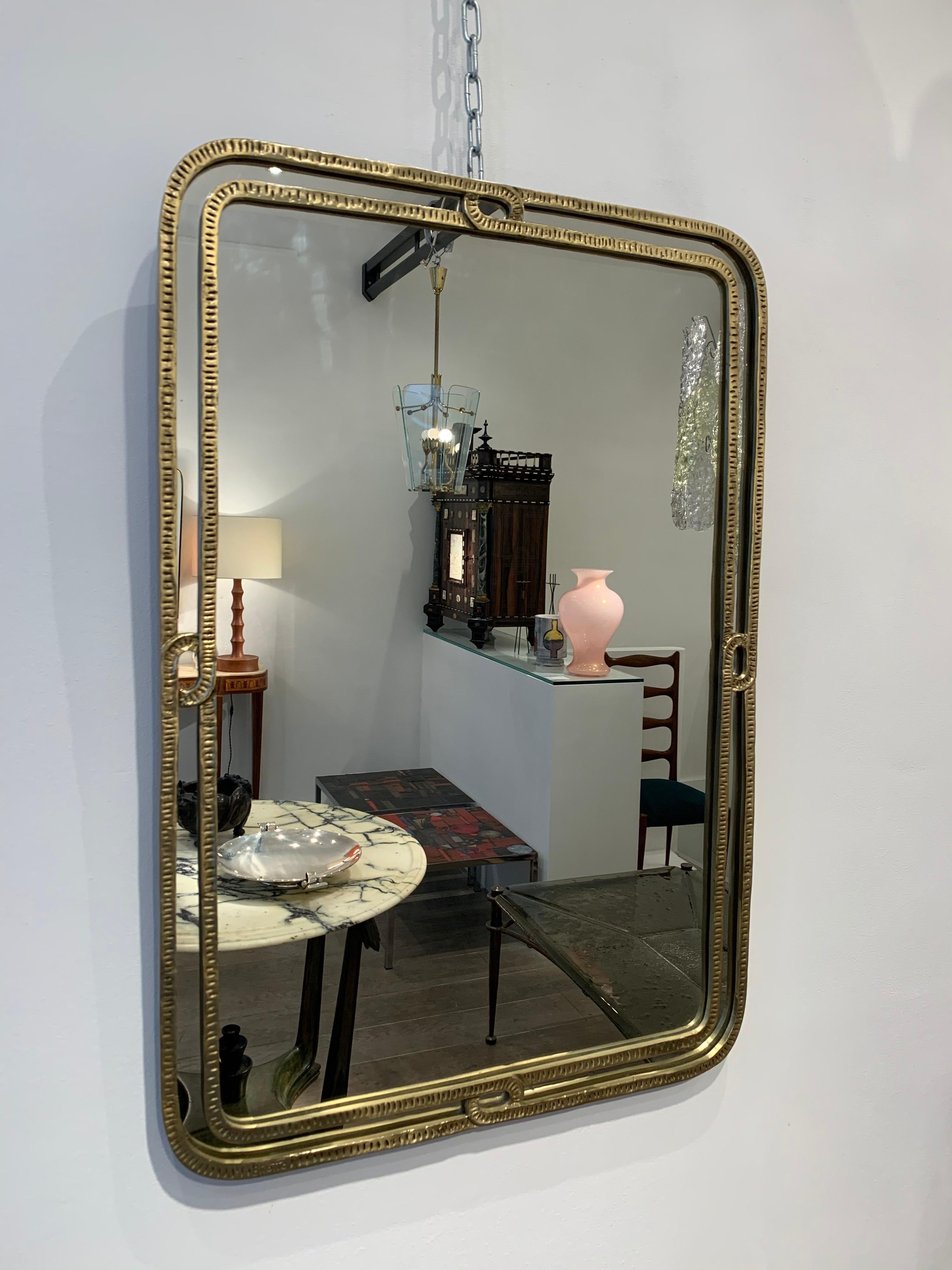 Angelo Brotto is a famous Italian designer, who specialized in lights and wall decoration. This mirror, which signed, is something rare and very elegant in his work.