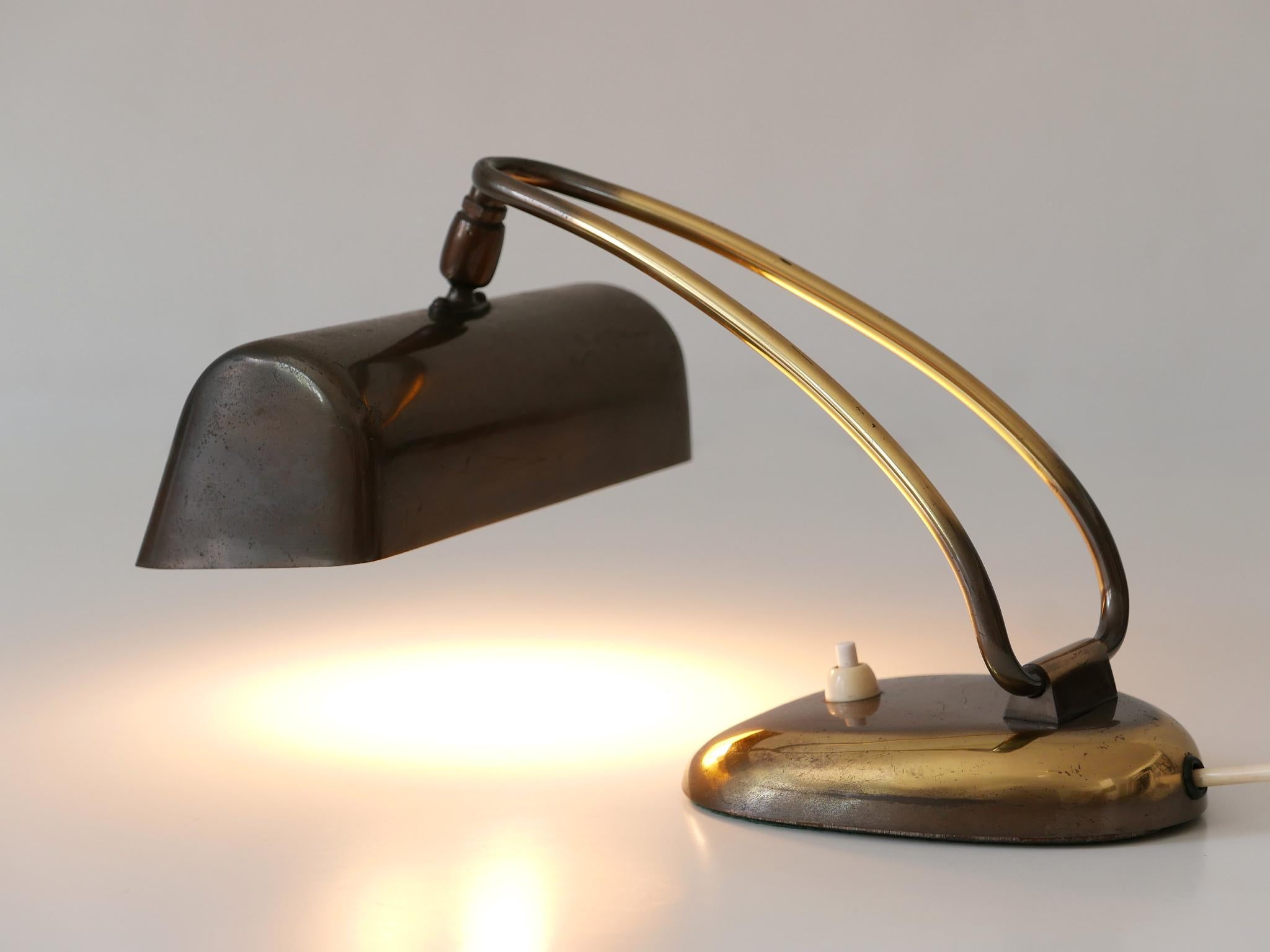 Rare and elegant Mid-Century Modern piano lamp or desk light. Adjustable height and shade. Designed and manufactured in 1950s, Germany. 

Executed in solid and perforated brass and cast iron, the desk / piano lamp comes with 1 x E14 / E12 Edison