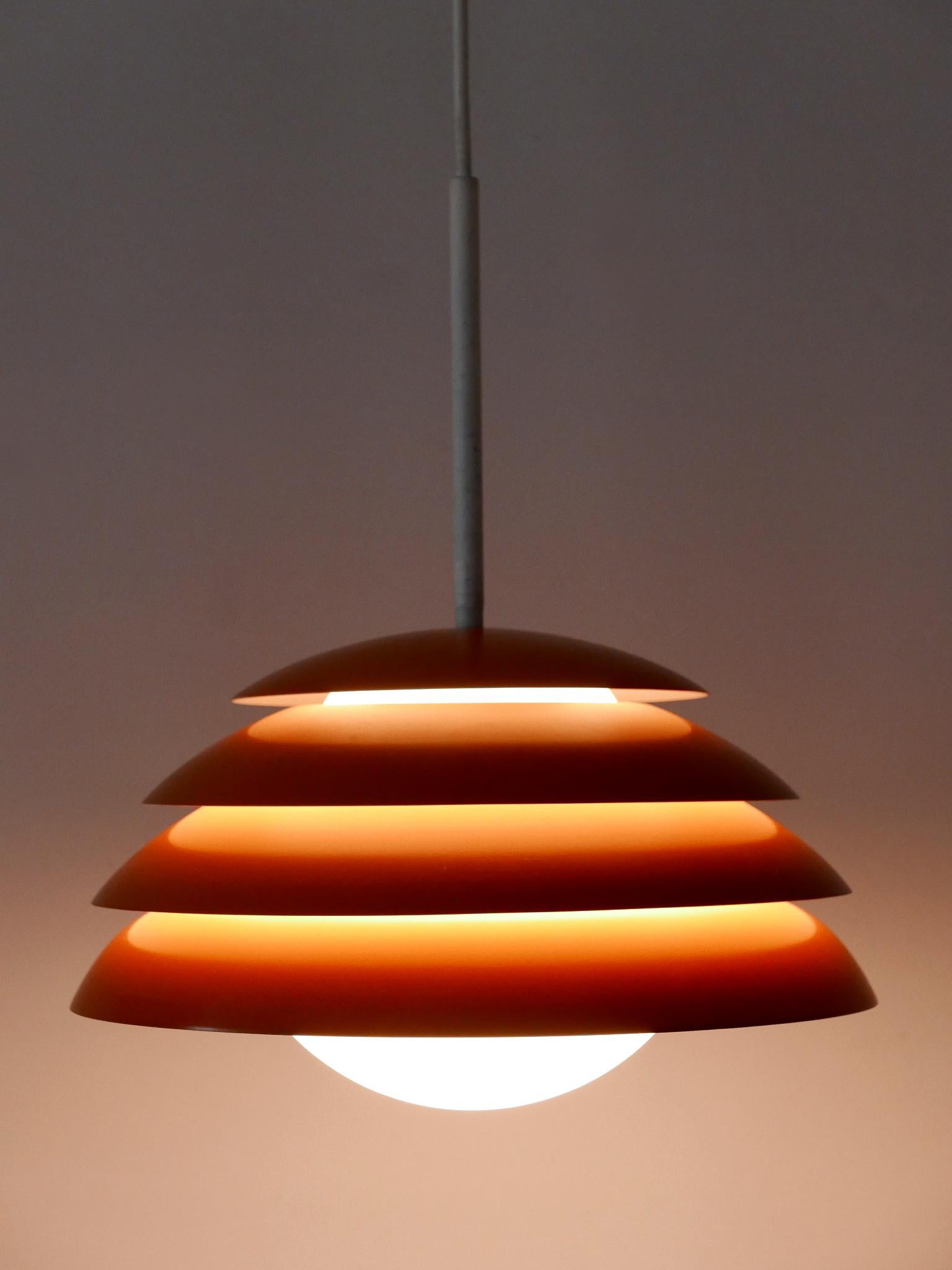 Lovely and highly decorative Mid-Century Modern pendant lamp or hanging light. Designed and manufactured in Germany, 1960s.

Executed in orange enameled aluminium and opaline glass, the pendant lamp comes with 1 x E27 / E26 Edison screw fit bulb