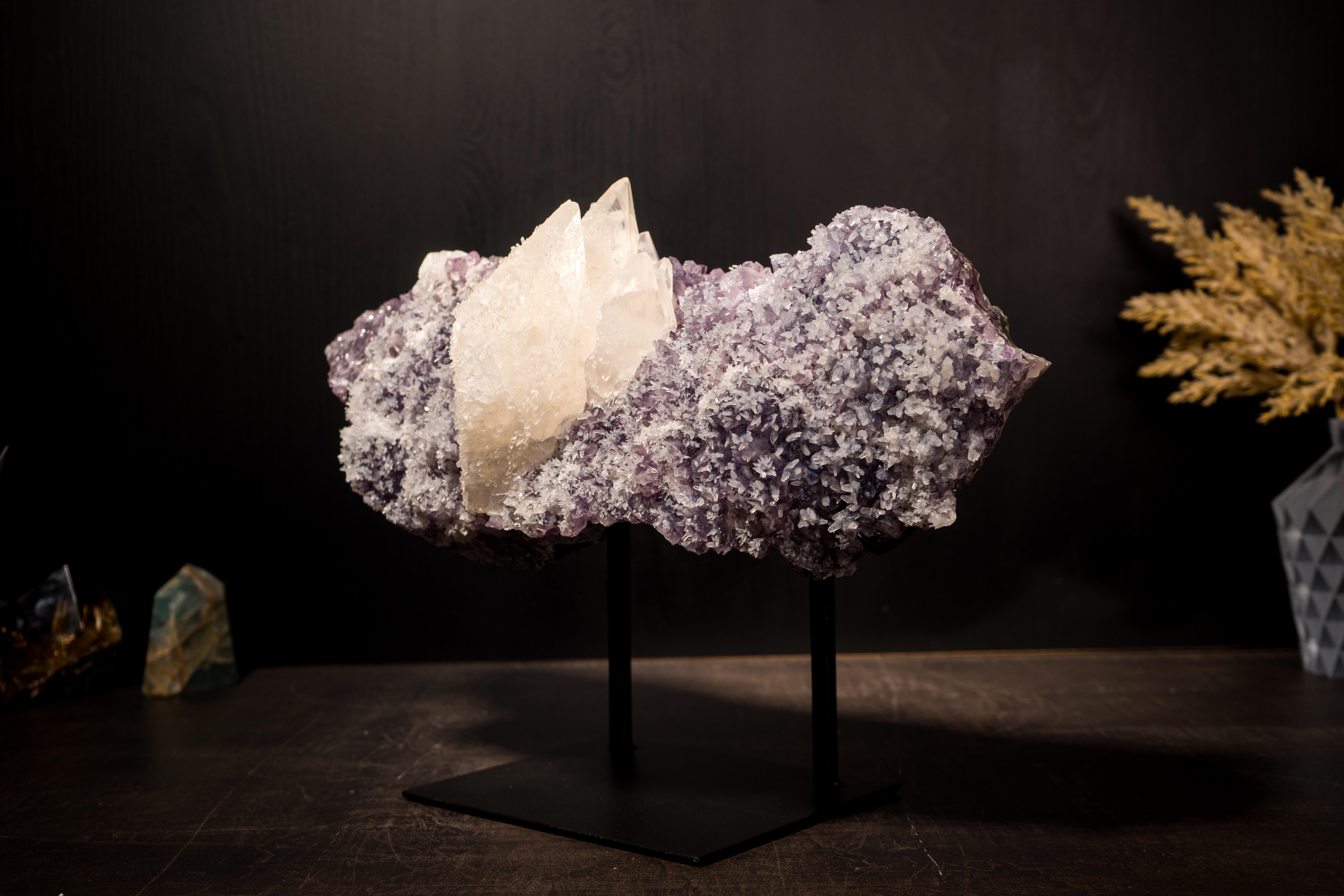 Con una splendida estetica, questa calcite a scaglie intatta poggia su un grappolo di ametista ornato da piccoli fiori di calcite, che la rendono un centrotavola eccezionale per la tua collezione o per il tuo spazio.

Il punto focale è la calcite,