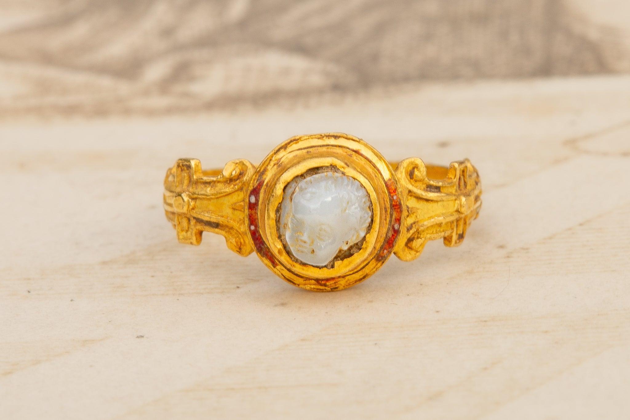 This exquisite Elizabethan gold ring dates to the mid-16th century (c.1570) and features a circular bezel set with a high-relief cameo of Cupid, delicately carved in white chalcedony. Cameos of Cupid, or Eros, were a popular motif during the