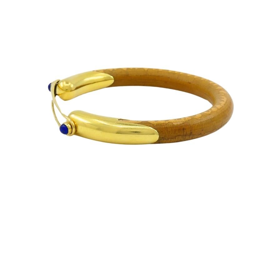 Rare Elsa Peretti  for Tiffany & Co. rattan bracelet, featuring 18k gold and lapis lazuli. 
The bracelet brings together a warm, natural rattan core with sleek 18k yellow gold elements. The bracelet is gently curved, while the open-top design is