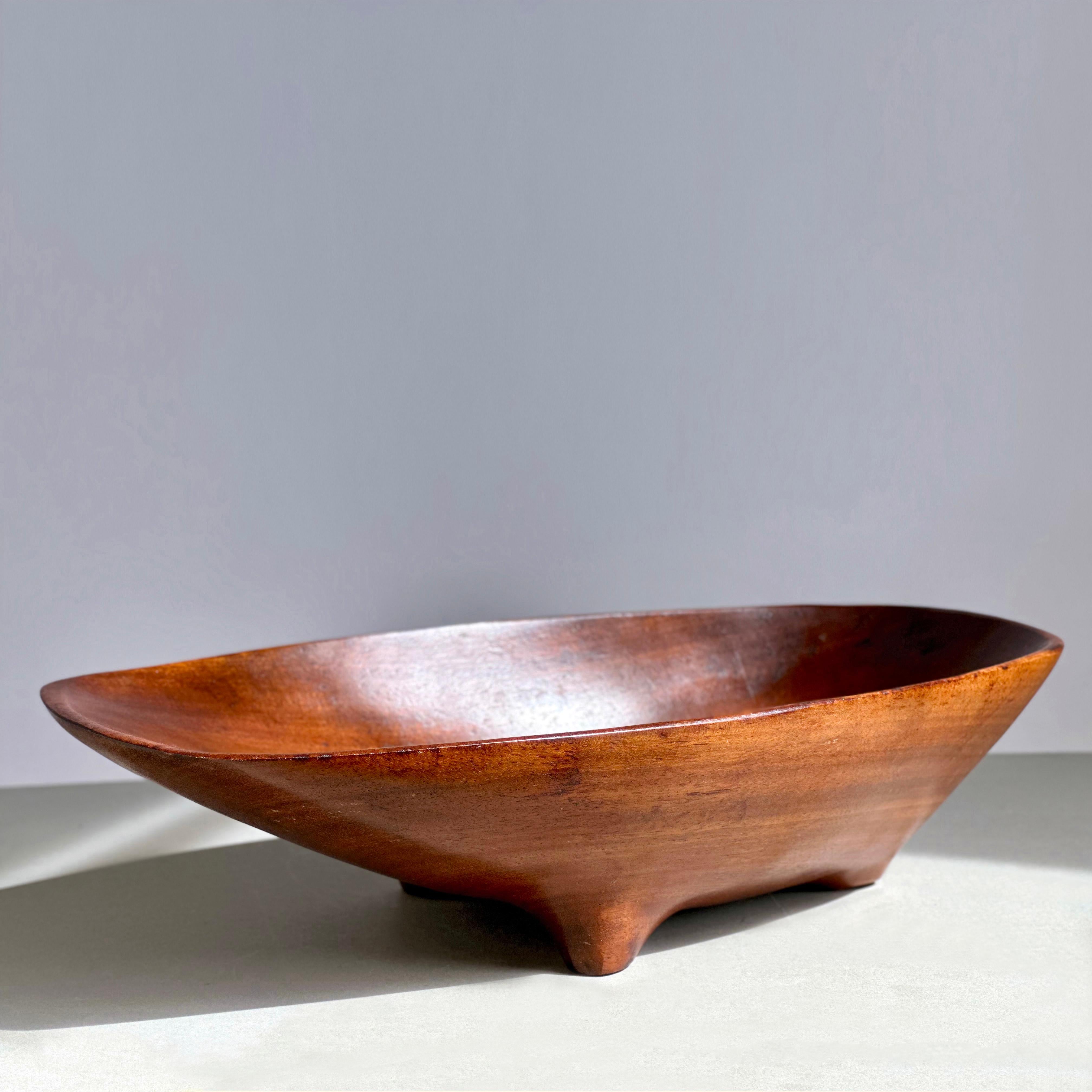 A tri-footed Mask Bowl in hand-carved bissilon by Emil Milan. This design, whose underside appears as a tribal mask, was one of several conceived by Milan and Joyce Anderson for the 1964 USAID (Agency for International Development) project they