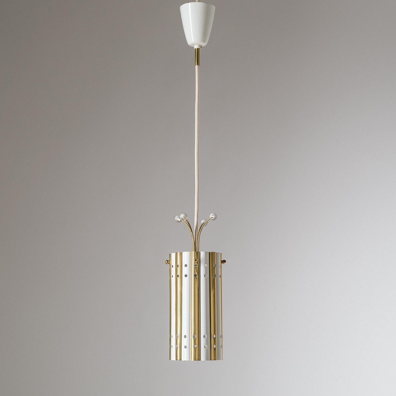 Very rare brass pendants/lanterns attributed to Emil Stejnar, 1950s. Made of sculpted sheet brass with alternating white lacquered stripes these unique pendants have four rows of star shaped cutouts and are topped off with charming glass adorned