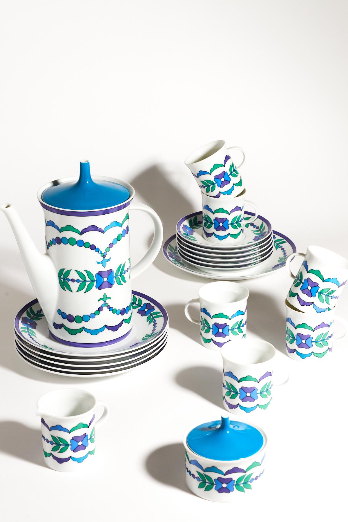 Beautiful Pucci design porcelain coffee set including tall pot with peacock blue lid, sugar bowl with similar lid, creamer and six cup, saucer and plate sets, stylised floral pattern in peacock blue, green, sky blue and violet on crisp white, signed